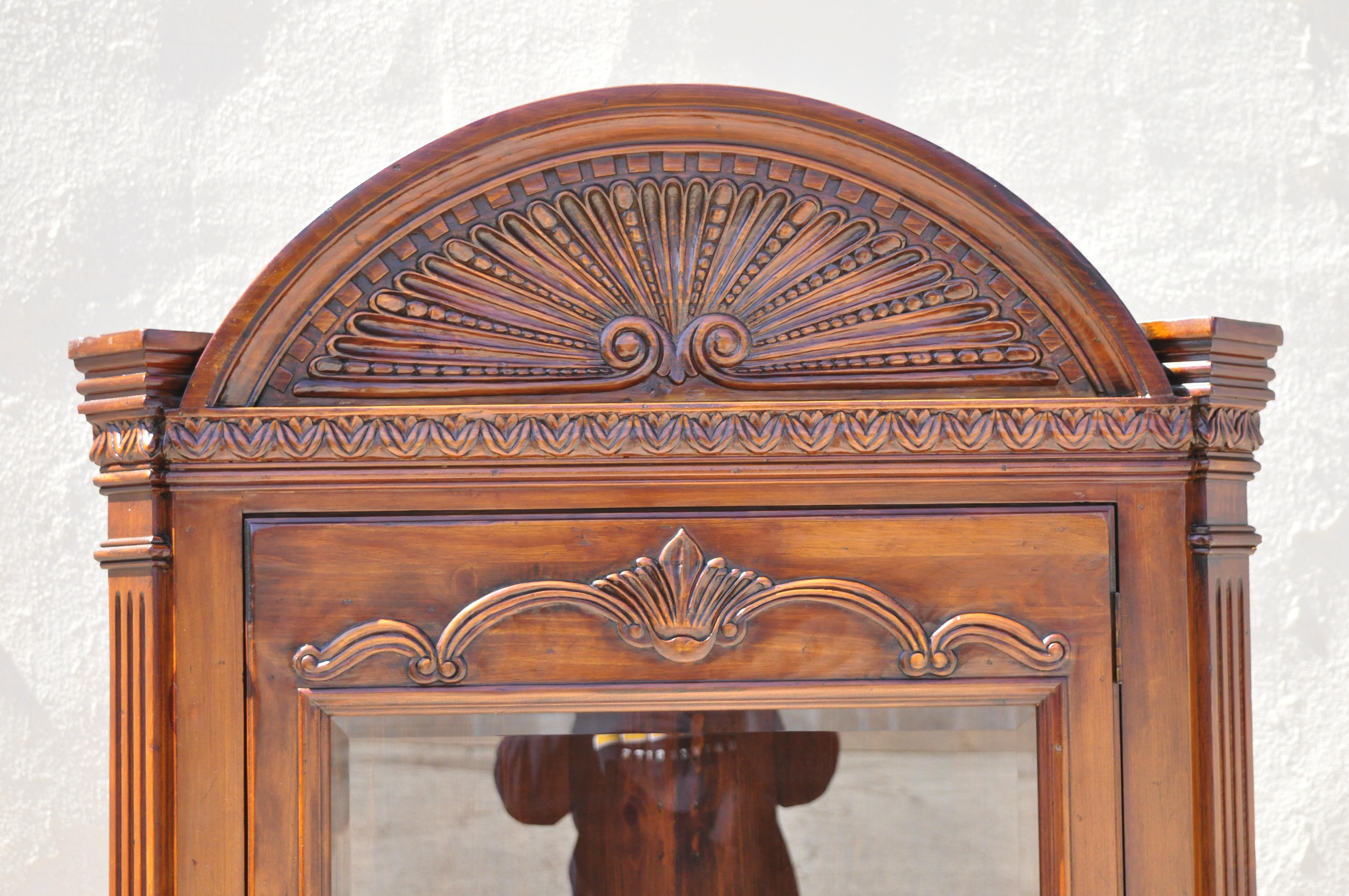 Reproduction d'une armoire d'angle en bois de pin sculpté en forme de coquillage de style Renaissance italienne. L'article présente une construction en bois massif, un beau grain de bois, des détails joliment sculptés, un intérieur éclairé, une