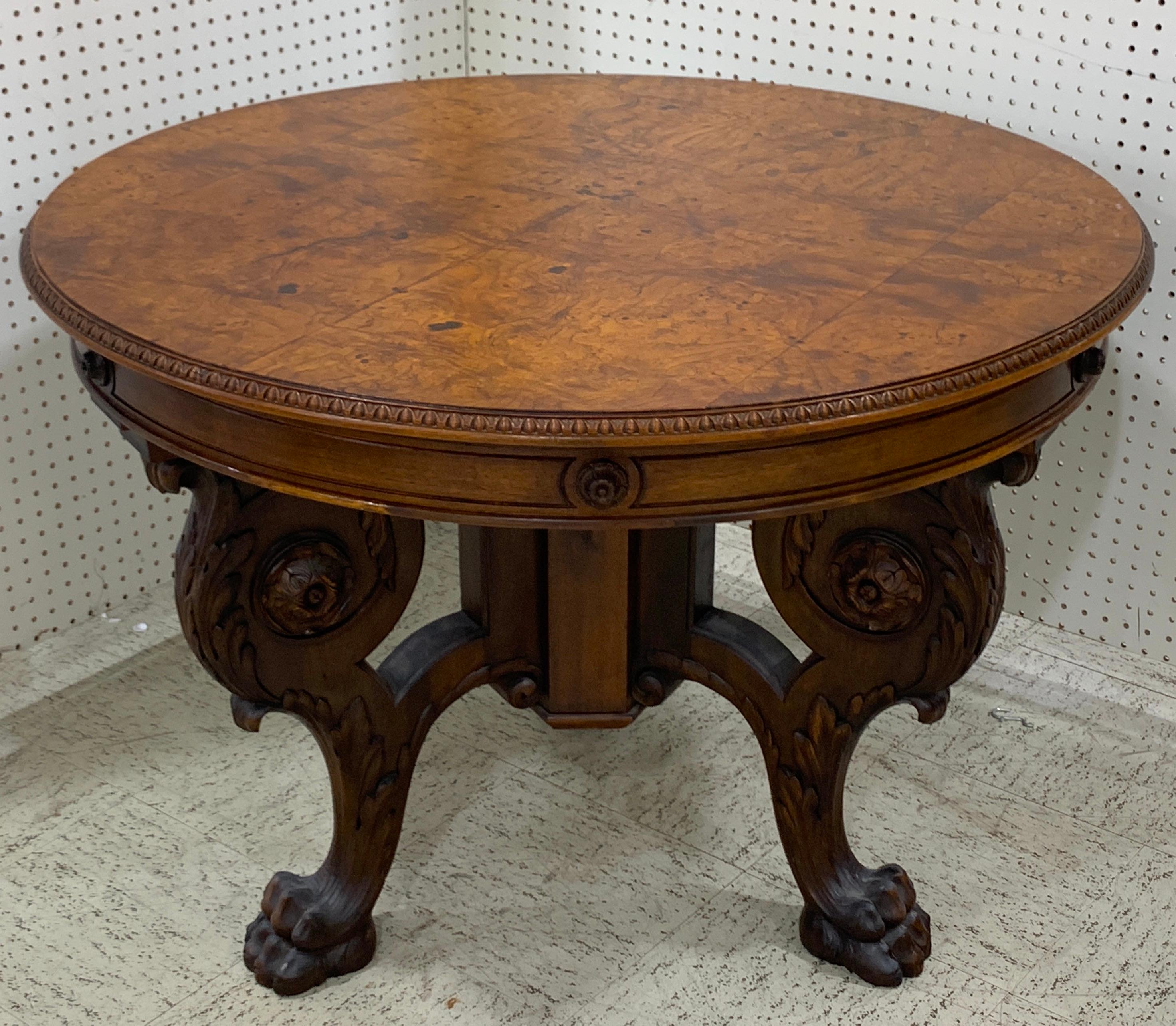 Italian Renaissance style walnut and burl round table, beautiful bookmatched top with egg and dart edge, raised on a strong, finely carved acanthus medallion tripartite paw foot base.
