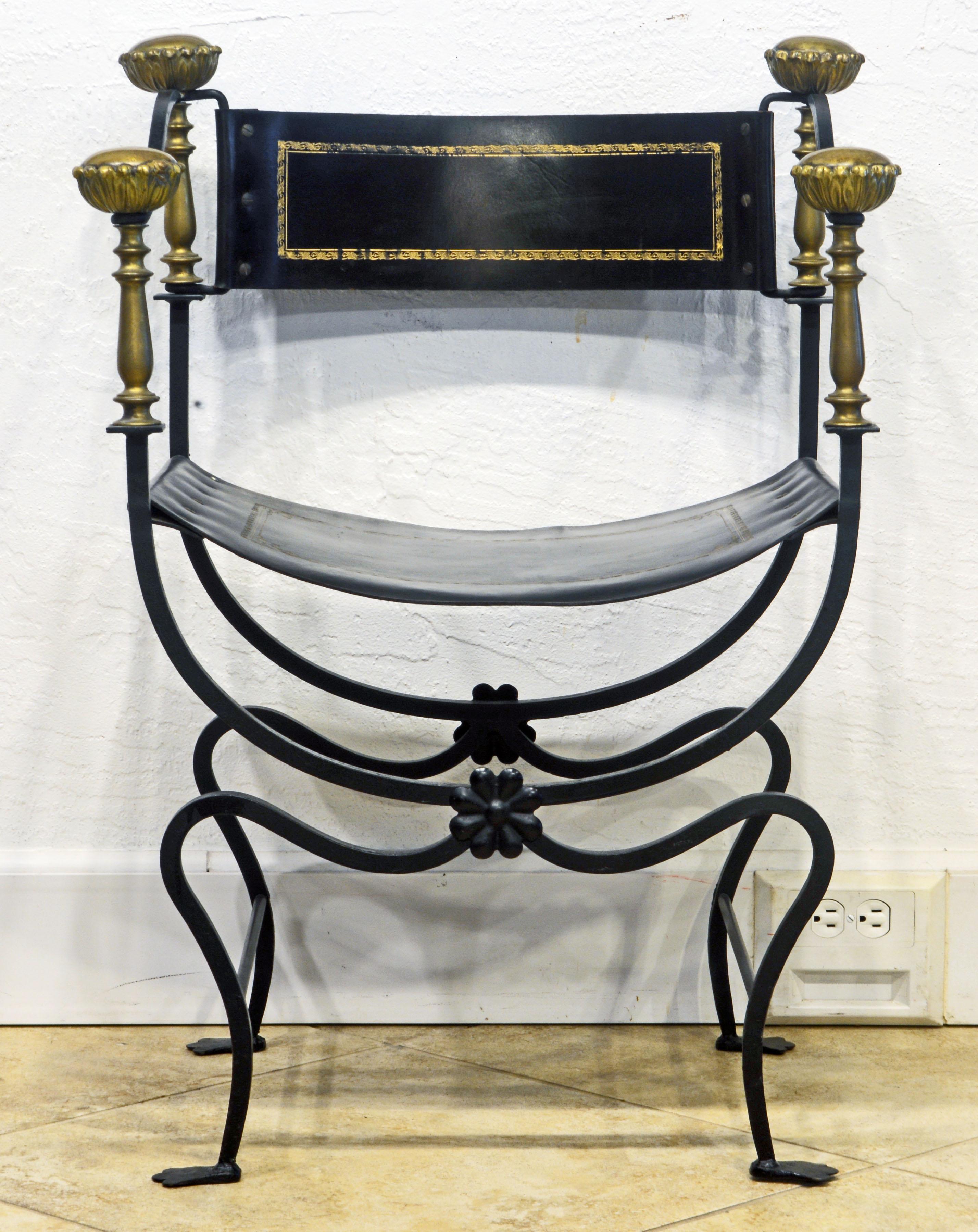 Vintage Mizner style Italian Renaissance-revival Savonarola chair with black painted curvy wrought iron frame, gilt tooled leather seat and back, and sculptural solid brass finials.