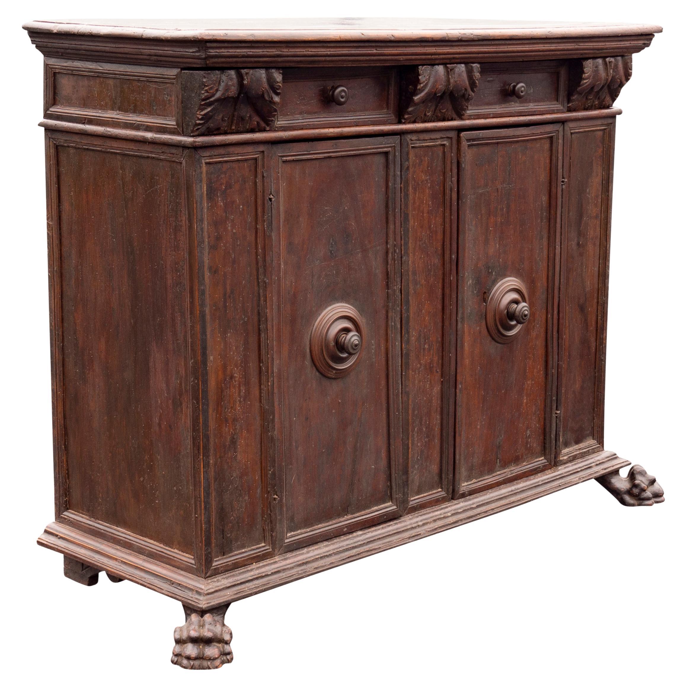 With a rectangular top with molded edge over a frieze with two drawers flanked by three acanthus carved corbel shaped drawers, pair cabinet doors below with central turned wood knobs, all raised on carved paw feet. Provenance; Fogg Family, Chestnut