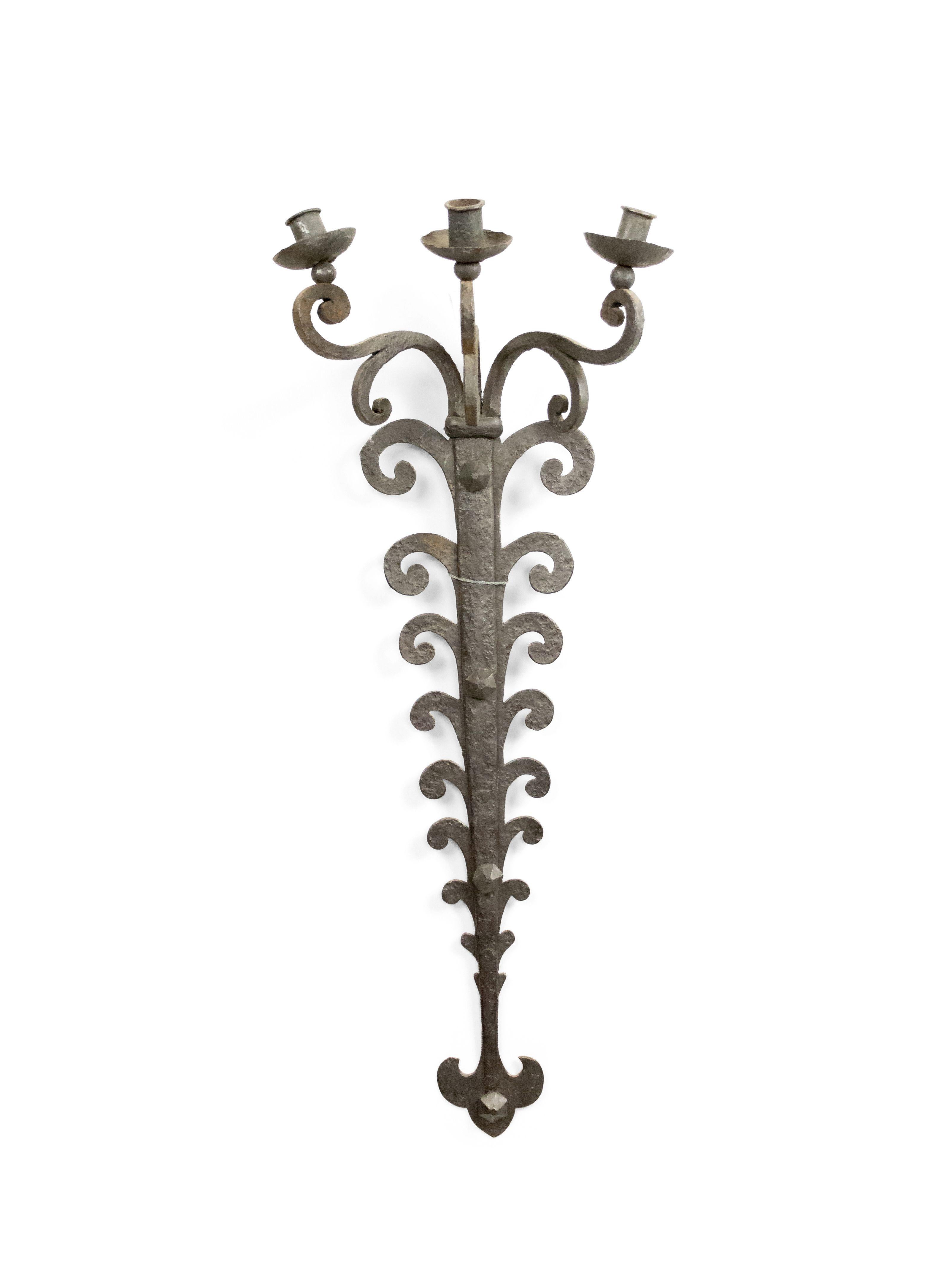 Pair of Italian Renaissance style (20th Century) wrought iron sconces with 3 scroll arms supported by a tapered and tiered scroll design backing.