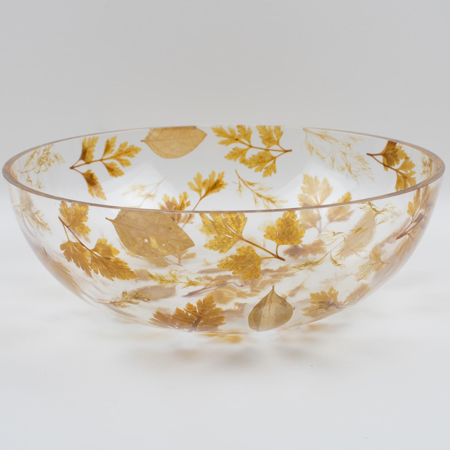 A lovely resin decorative bowl, centerpiece, or serving dish designed by Resinplast Italy in the 1970s. Extra thick clear resin or acrylic in a deep rounded bowl shape with assorted real autumn leaves embedded in the material. The natural light