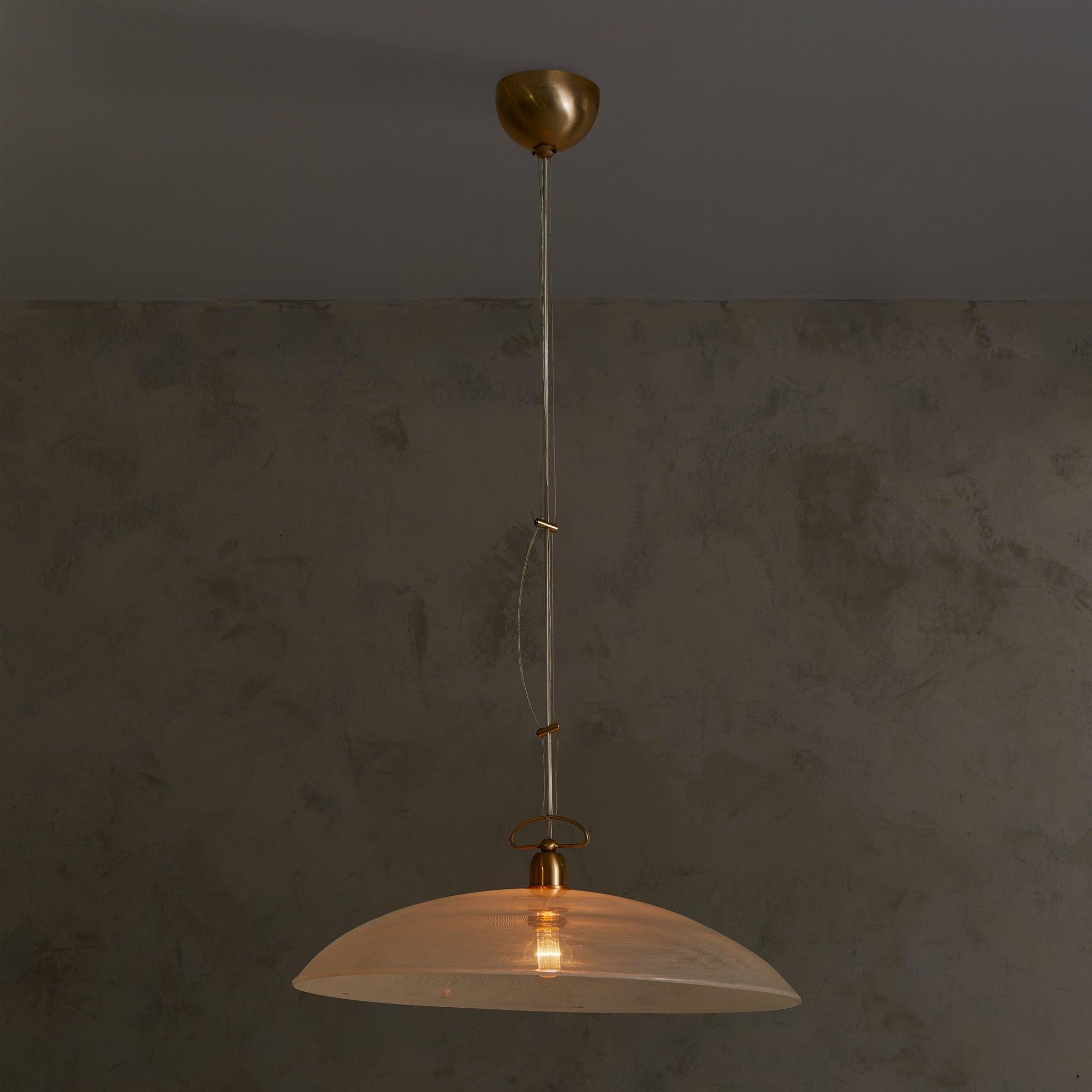 A 1970s Italian pendant in blown Murano glass, suspended from its original brass canopy with adjustable tension wires. The wide, shallow dome is rendered in delicate reticello—a centuries-old glassblowing technique marked by a fine, crisscrossing