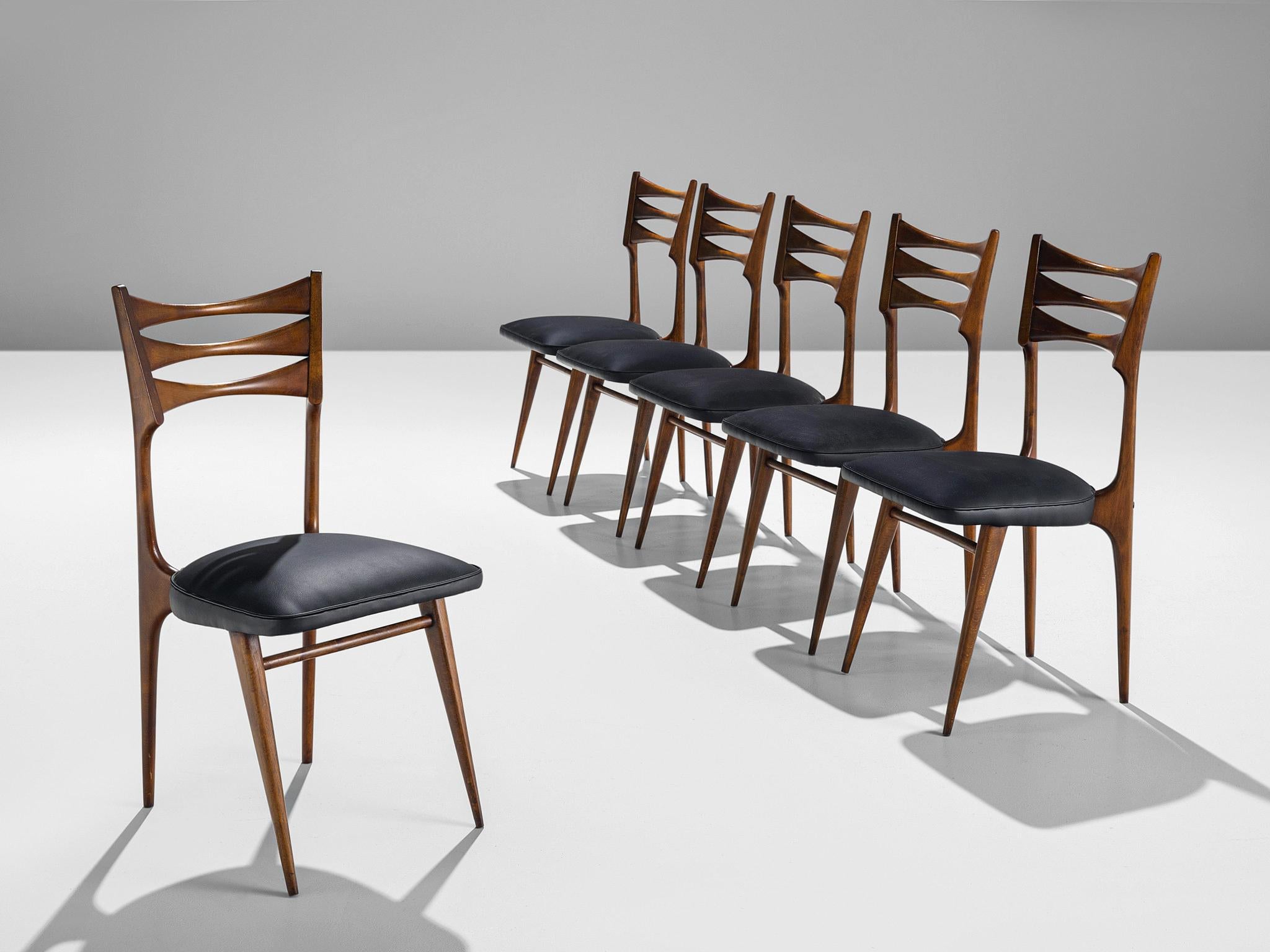 Set of six dining chairs, walnut, leatherette, 1960s, Italy.

This set of six elegant dining chairs is made in Italy in the 1960s. These pieces are sculptural, delicate, and well-constructed. The back shows an open frame with two oval cut outs, the