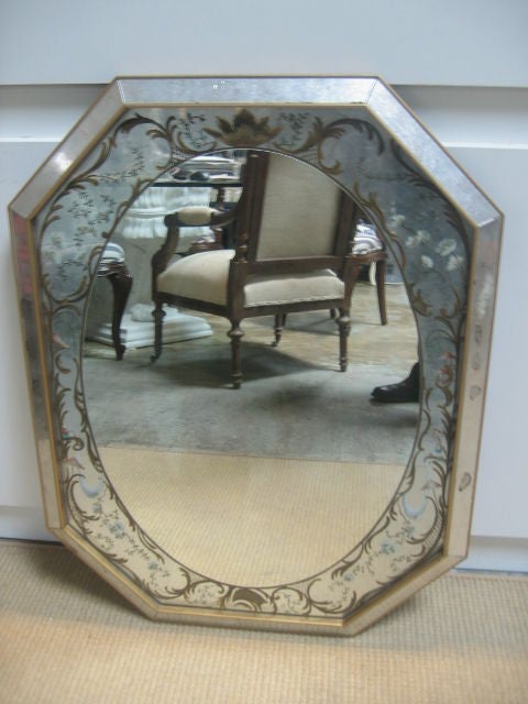 Beautifully hand painted mirror with scrollwork and floral motifs. The frame is beveled, antiqued mirror with matte gold painted edges. The glass has a faint antique wash.