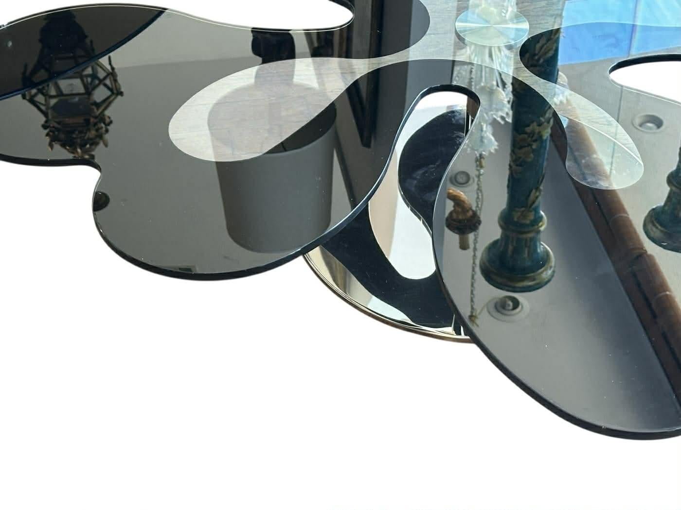 Il tavolino in vetro contemporaneo è caratterizzato da un piano in vetro a forma di ameba montato su una base cromata lucida. 