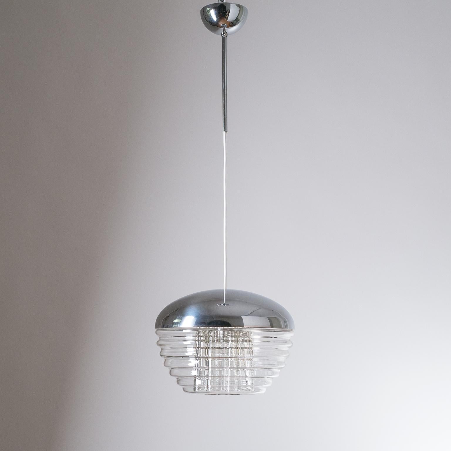 Rare Italian pendant, circa 1970, with a ribbed glass diffuser. The unusual clear glass body has a horizontal ribbed structure on the outside juxtaposed with vertical ribs on the inside. One E27 socket with new wiring.
Body height is