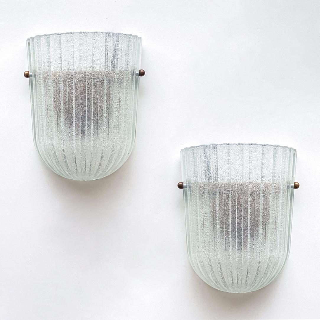Beautiful pair of Italian ribbed glass sconces with brass ball detailing. Oblong frosted glass with wide ribbed detail on glass. New brass interior fitting and socket. 

  