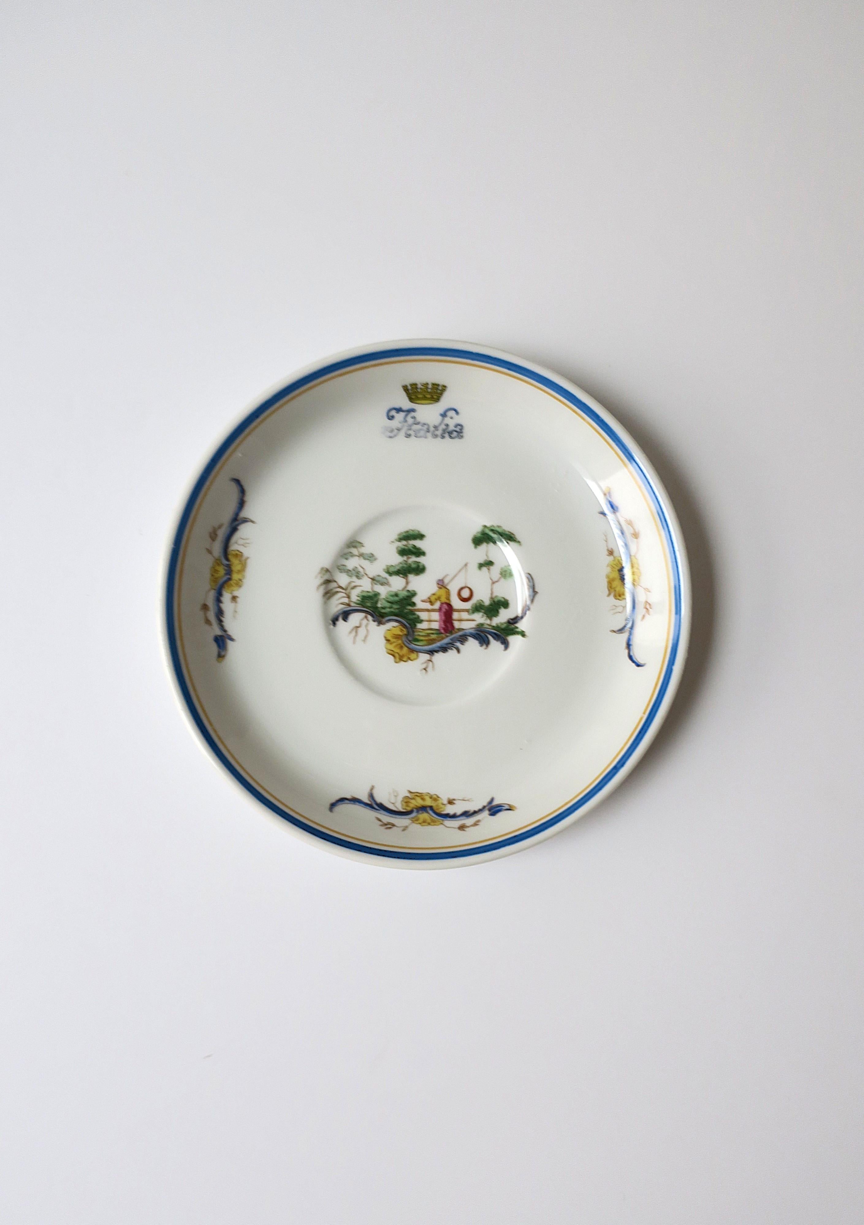 Piattino in porcellana italiana del designer Richard Ginori, in stile Chinoiserie, circa metà del XX secolo, Italia. Il piattino/piatto ha un disegno centrale di un uomo in un giardino con alberi bonsai, fiori gialli intorno al bordo interno e una