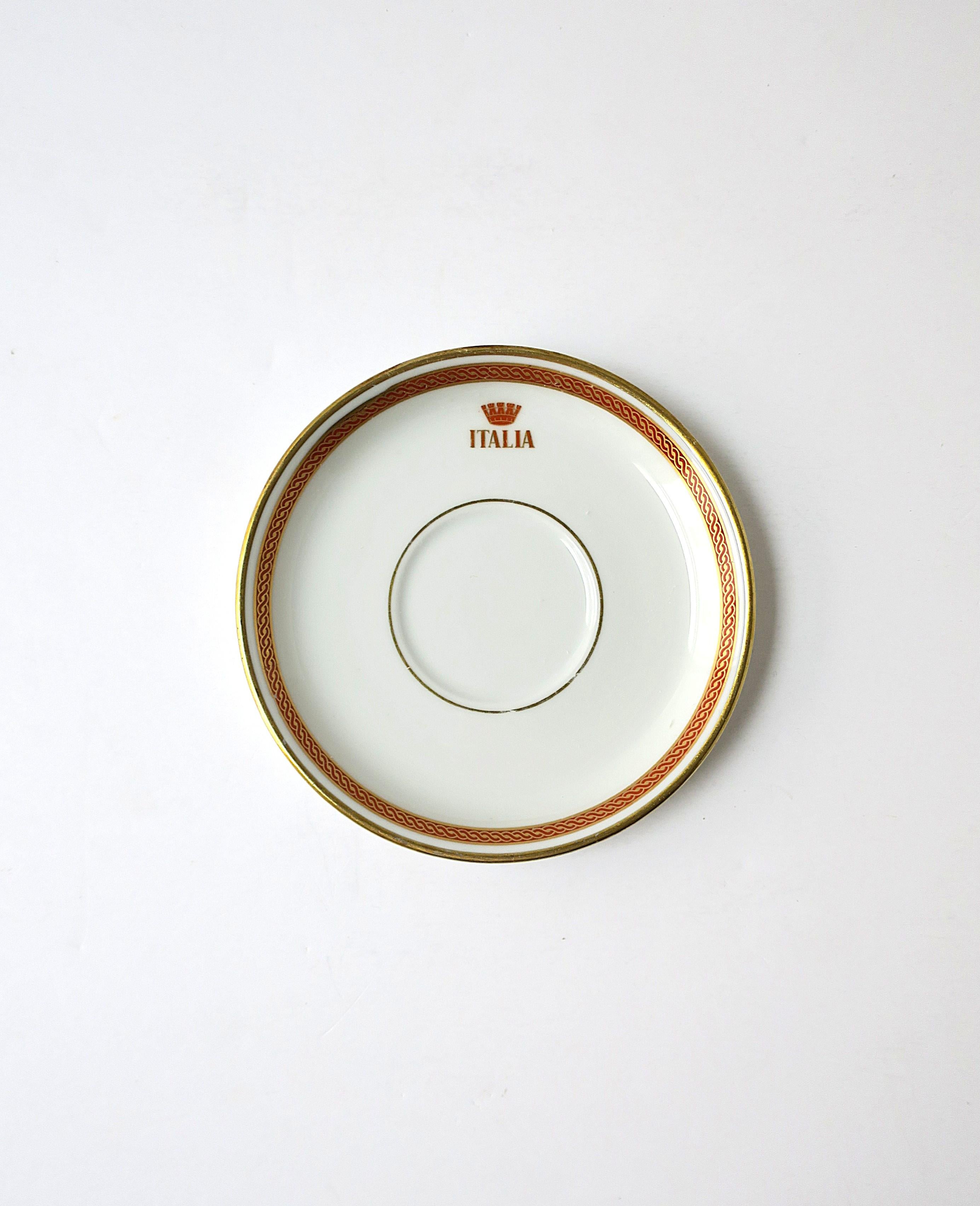An Italian porcelain saucer dish by designer Richard Ginori, circa mid-20th century, Italy. Saucer/dish has a red and gold design around edge, center top reading 'ITALIA'. Use as a jewelry dish or to hold other small items on a vanity, desk, etc.;