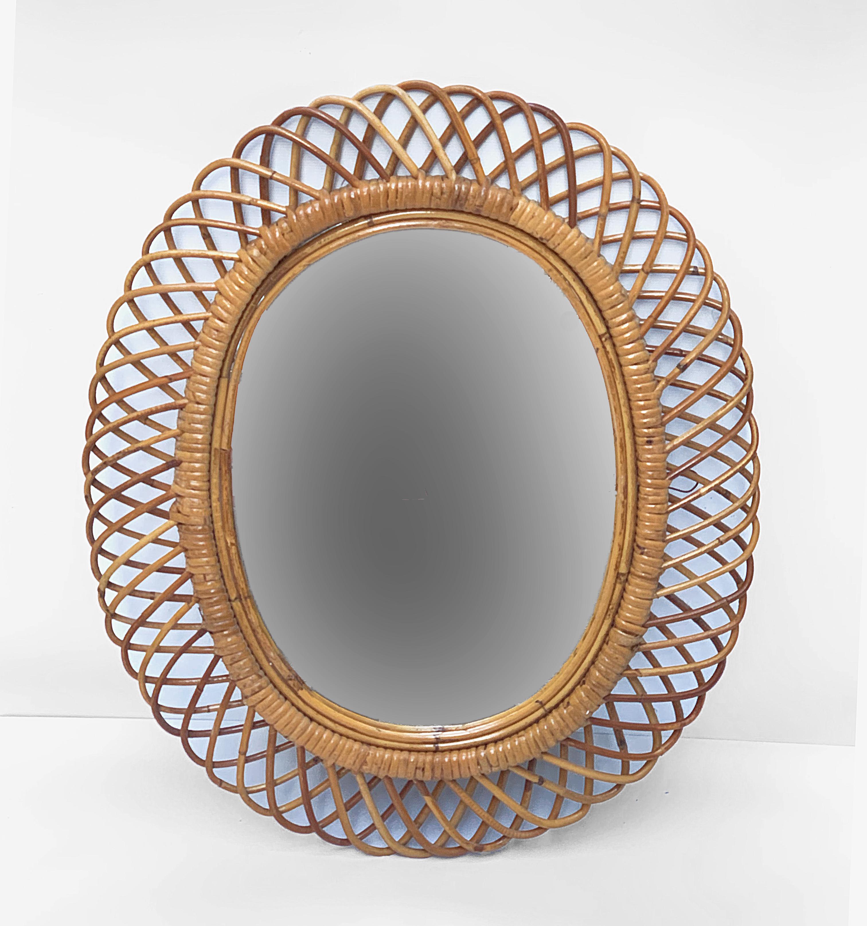 Very decorative oval mirror with curved rattan beams and bamboo frame.

This wonderful piece was produced in Italy during 1960s.

This amazing item would be perfect for a midcentury-style living room or bedroom.

Measurements (cms): 
Height