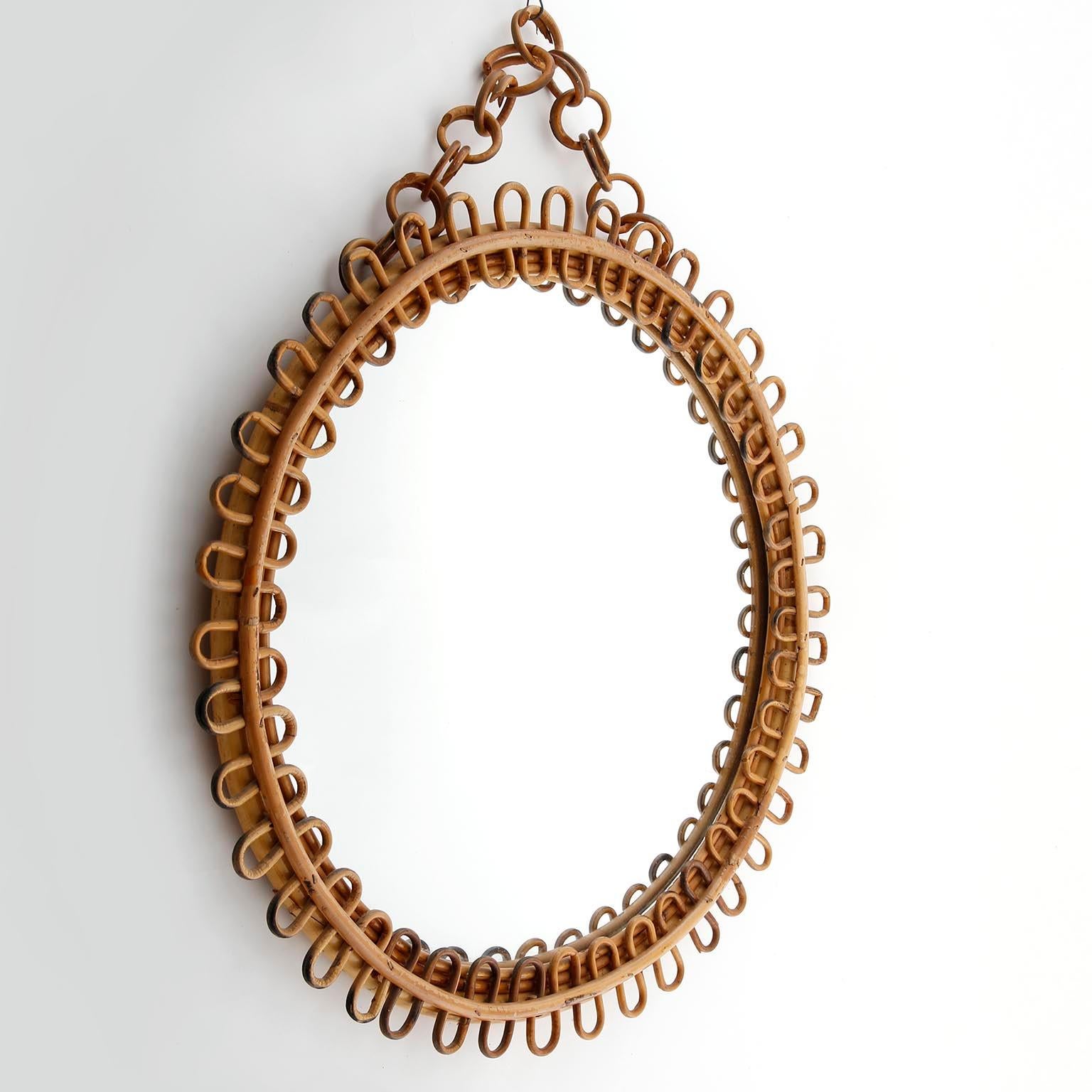 A handcrafted rattan and bamboo mirror hanging from a rattan chain. This beautiful mirror has all the taste of the Italian Riviera style.
Manufactured in Italy in midcentury, circa 1960.