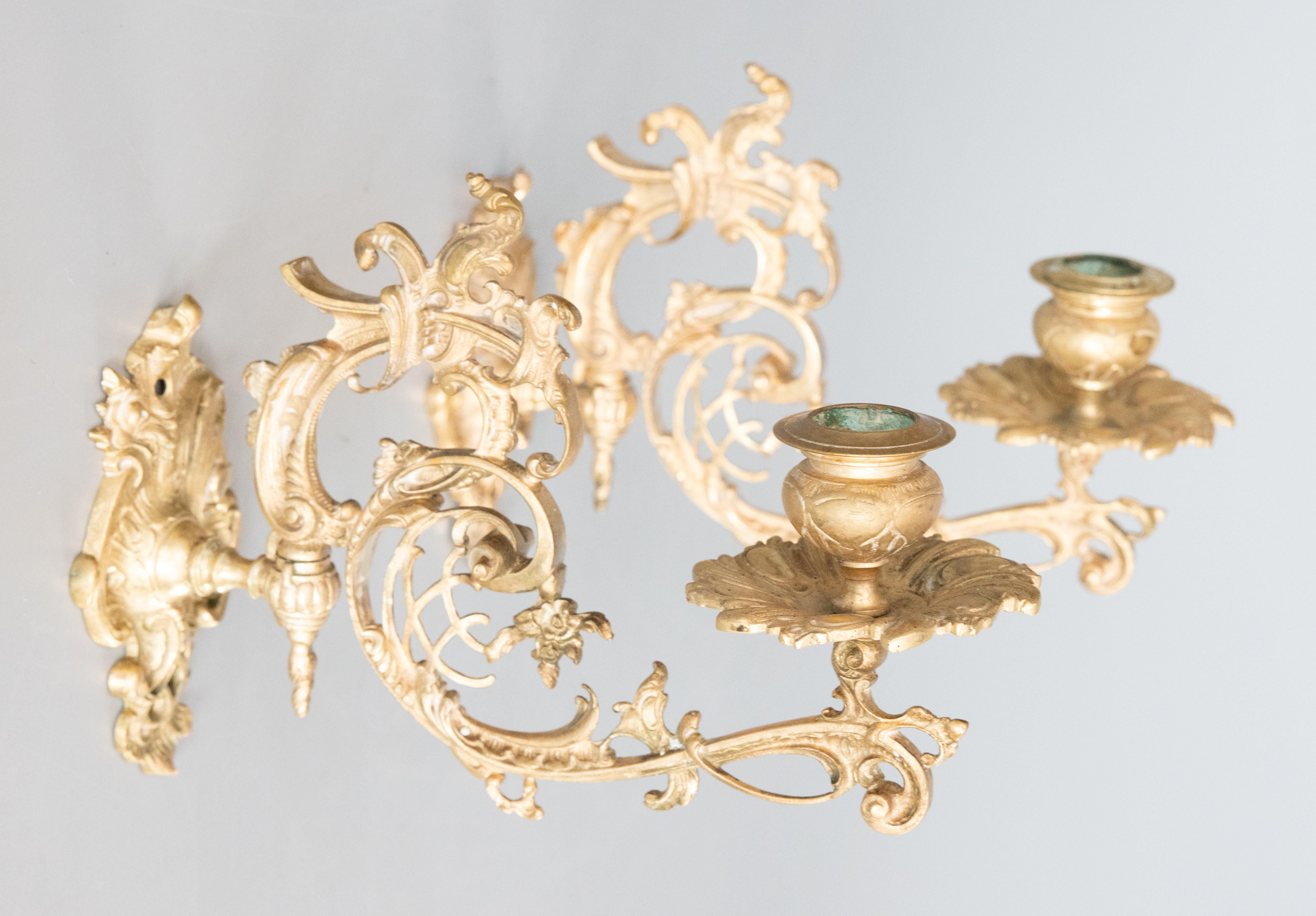 A beautiful pair of Italian gilt bronze candle sconces with openwork decor. Arms pivot to adjust position side to side. Maker's mark on the reverse. 