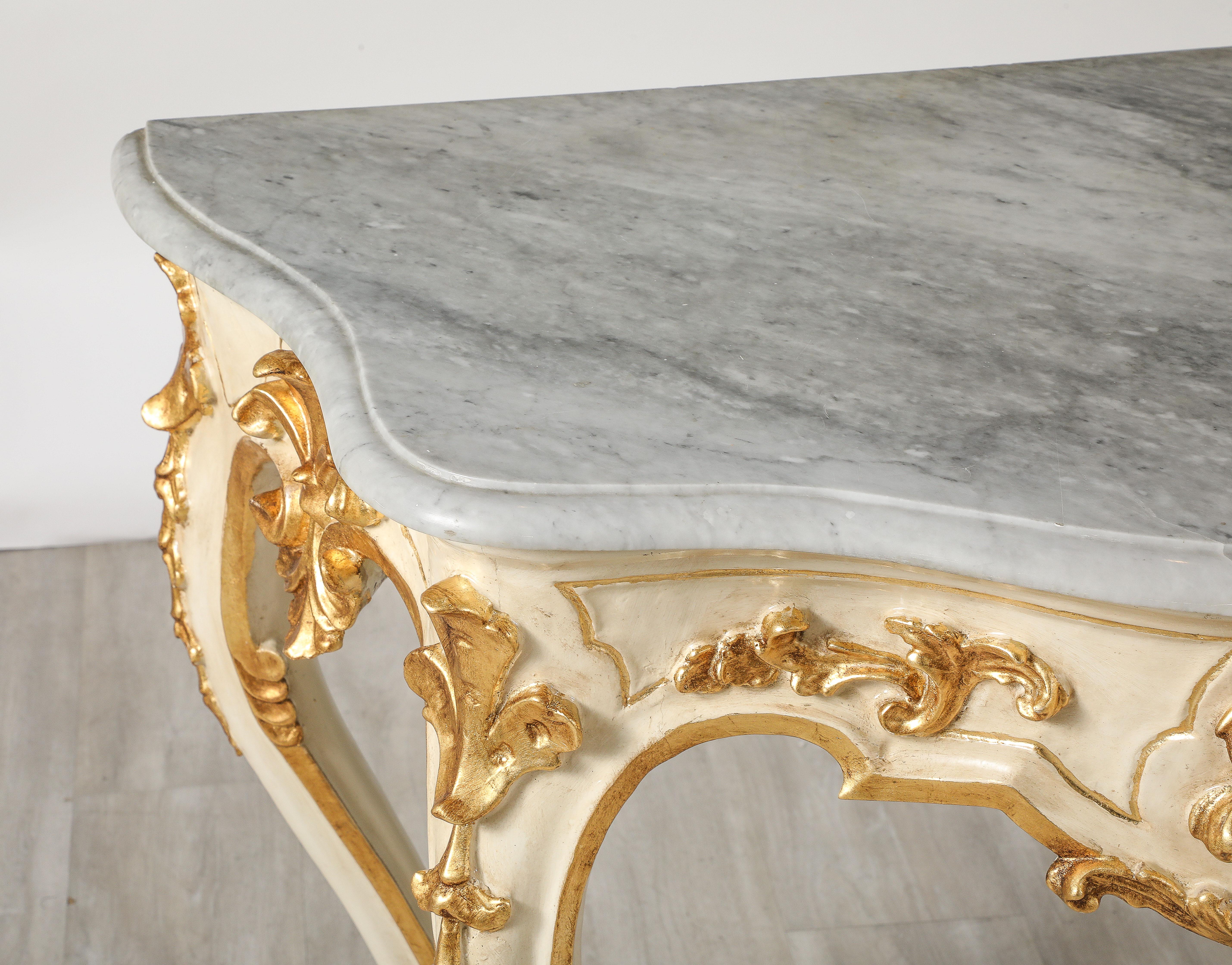 An extraordinary Northern Italian Rococo period gilded wood and hand-carved console with shaped grey marble top. The curved shape of the body, on the front, on the sides and of the feet and the rich carving are the result of the high level of