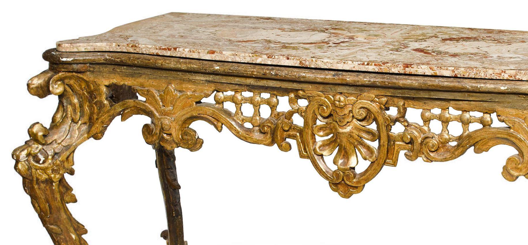 Impressive 18th century Italian Rococo hand-carved giltwood console.
The inset serpentine-fronted marble top is over carved giltwood frieze with Rocaille motif fretwork centred by two C-scrolls with a shell, supported by reversed scroll legs