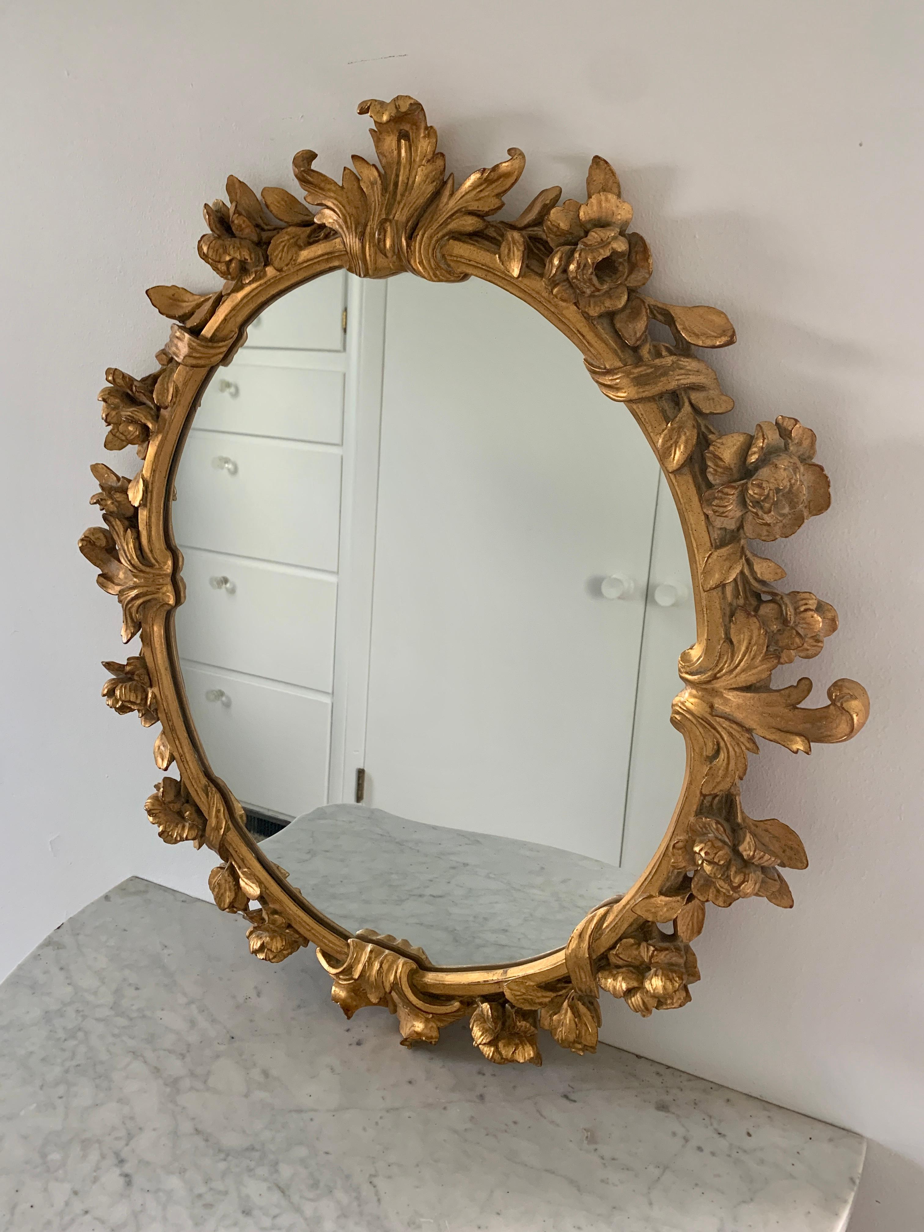 A stunning Rococo style wall mirror featuring foliate swags and carved roses

Italy, Late 20th century

Giltwood frame, with mirror glass

Measures: 26.25