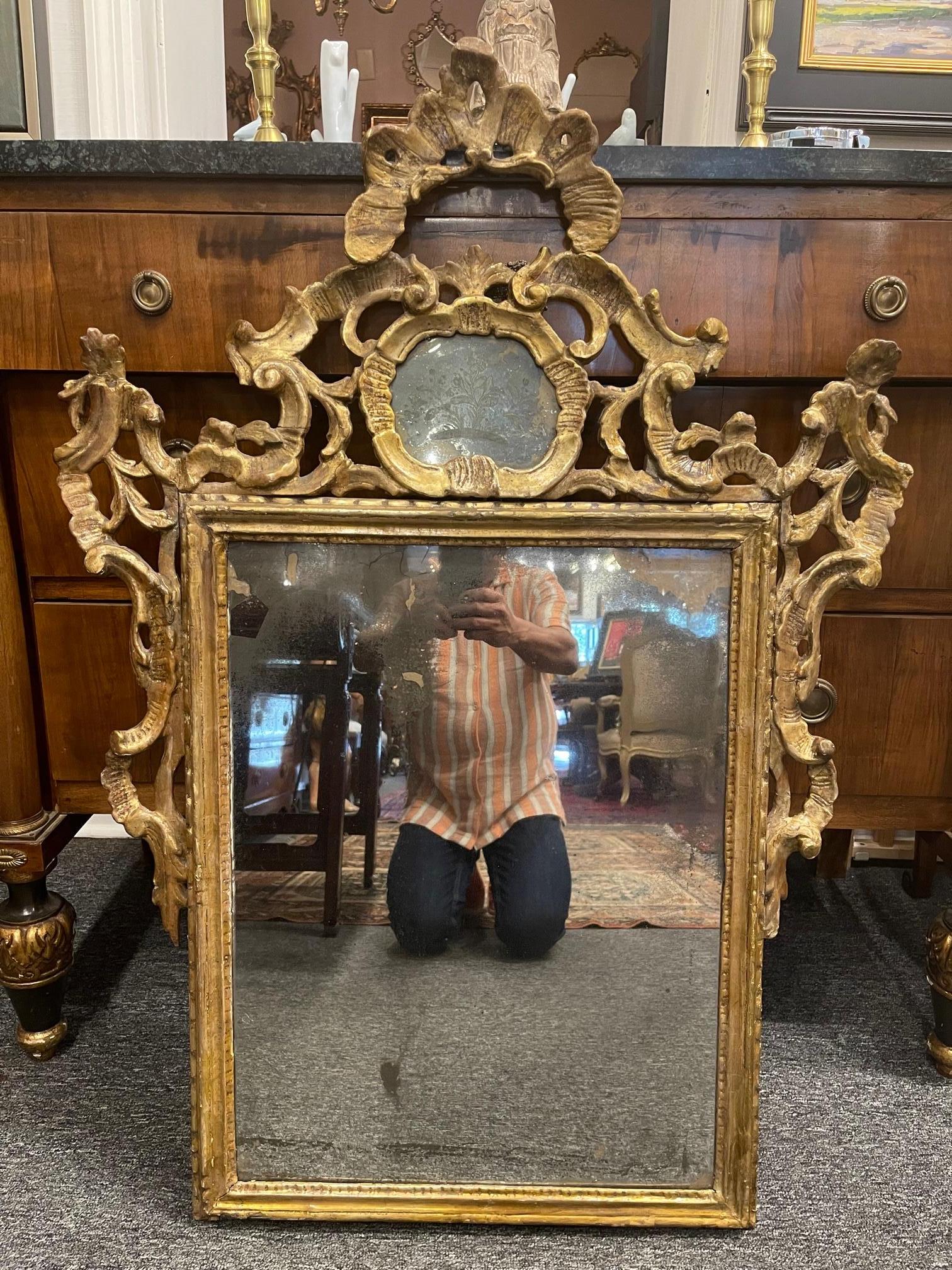 Italian Rococo giltwood wall mirror, 18th century; large open work crest. Small etched mirror panel above main mirror panel.