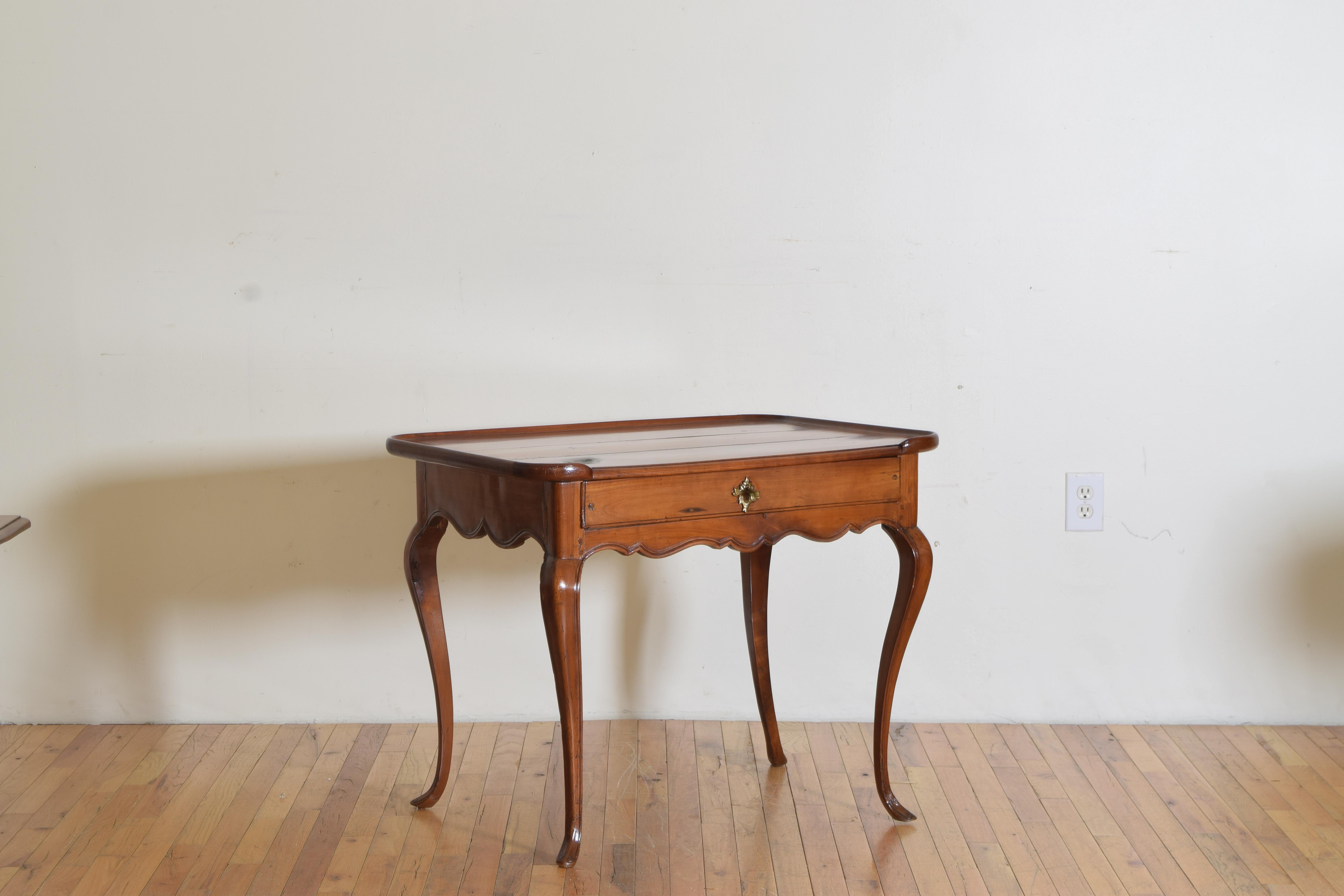 This elegantly imagined side table has a three quarter gallery top with a case housing one drawer and having a stylized carved apron, raised on cabriole legs anchored by uniquely shaped feet.