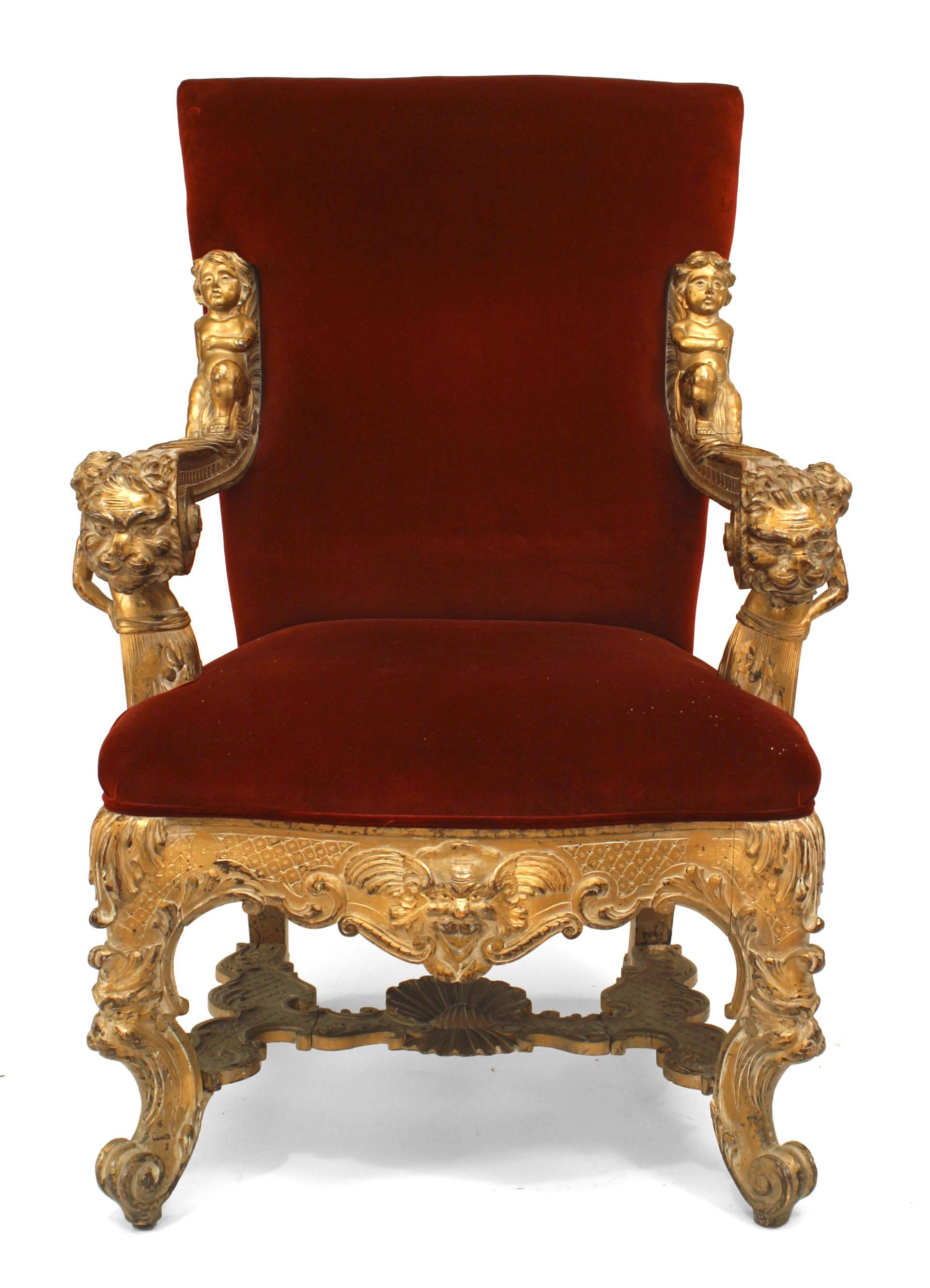 Late 19th, Early 20th Century Italian Rococo style gilt carved throne chair with stretcher and cupids on arms with lion head and red velvet upholstery.