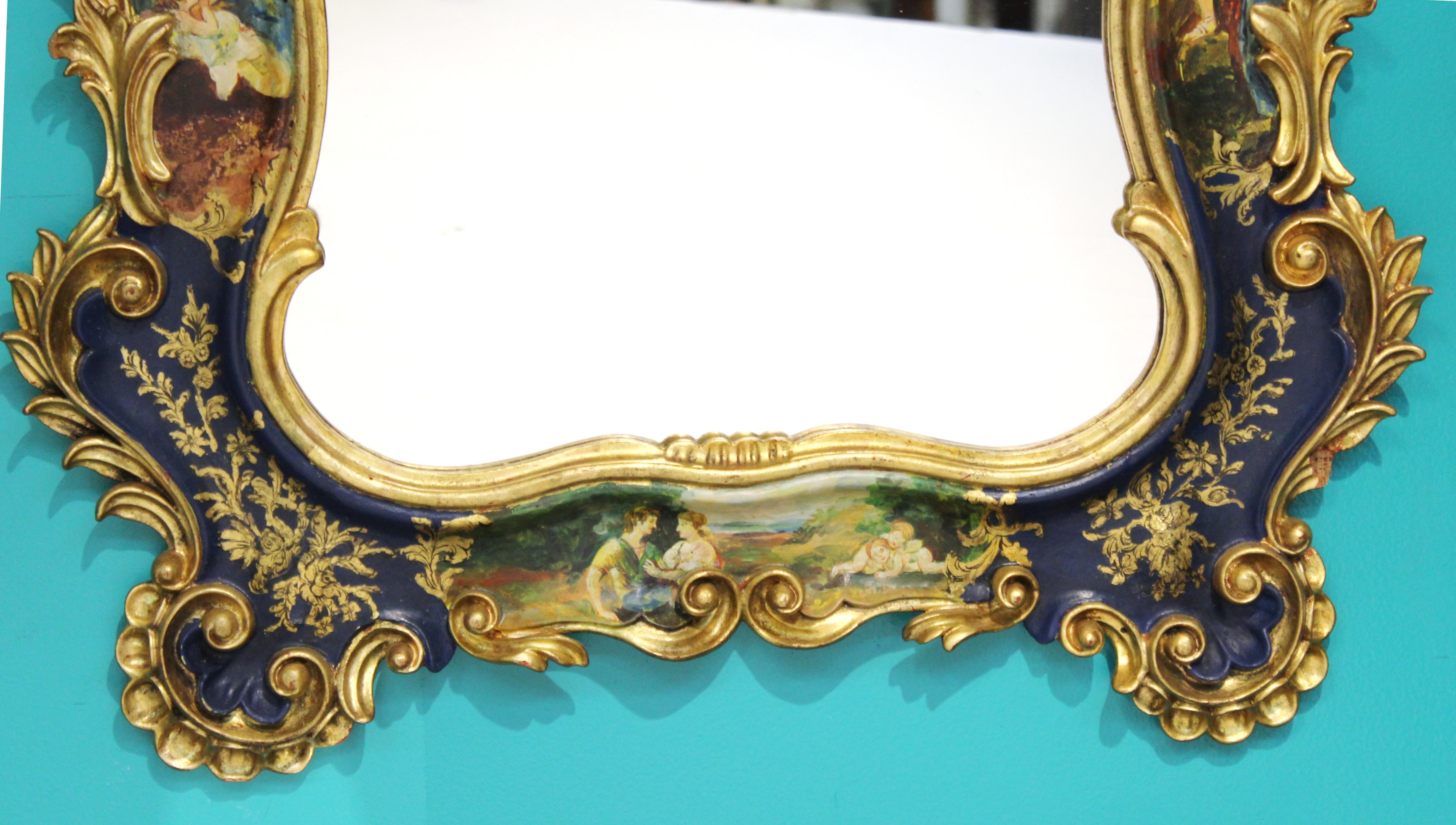 Italian Rococo Revival style hand painted wall mirror with elaborate decorations. Hand carved wood frame depicting bucolic scenes of romantic pursuits, painted in blues and greens, with giltwood embellishments. Made in Italy during the 1950s, the
