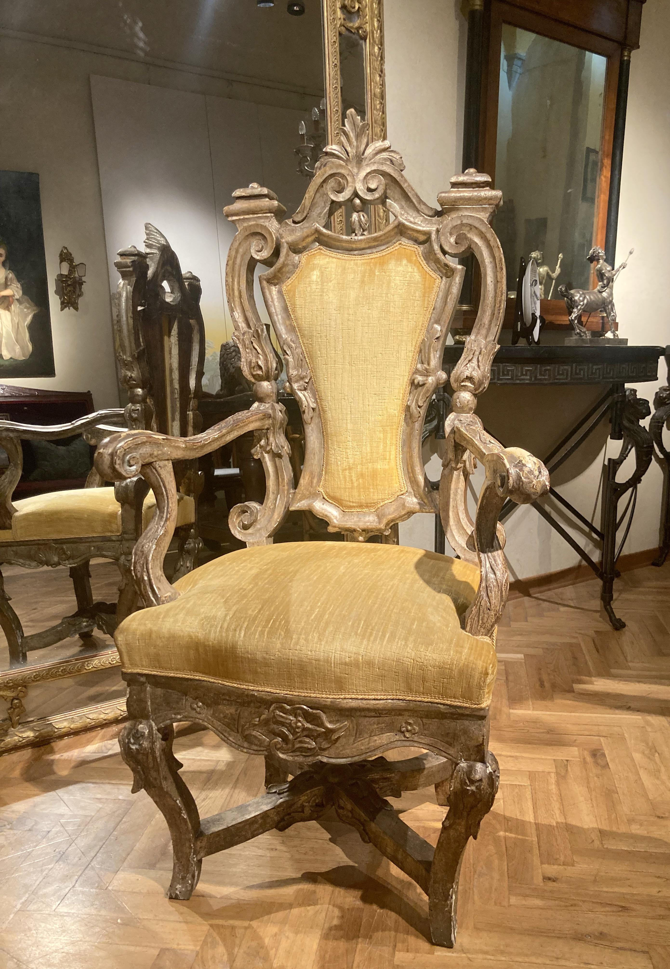 This antique Italian Rococo 17th century throne armchair sourced in a palazzo in Rome, features swirls, curls and foliate motif richly hand carved throughout, the solid wood deeply carved and pierced boasts a super chic mecca gilding with silver