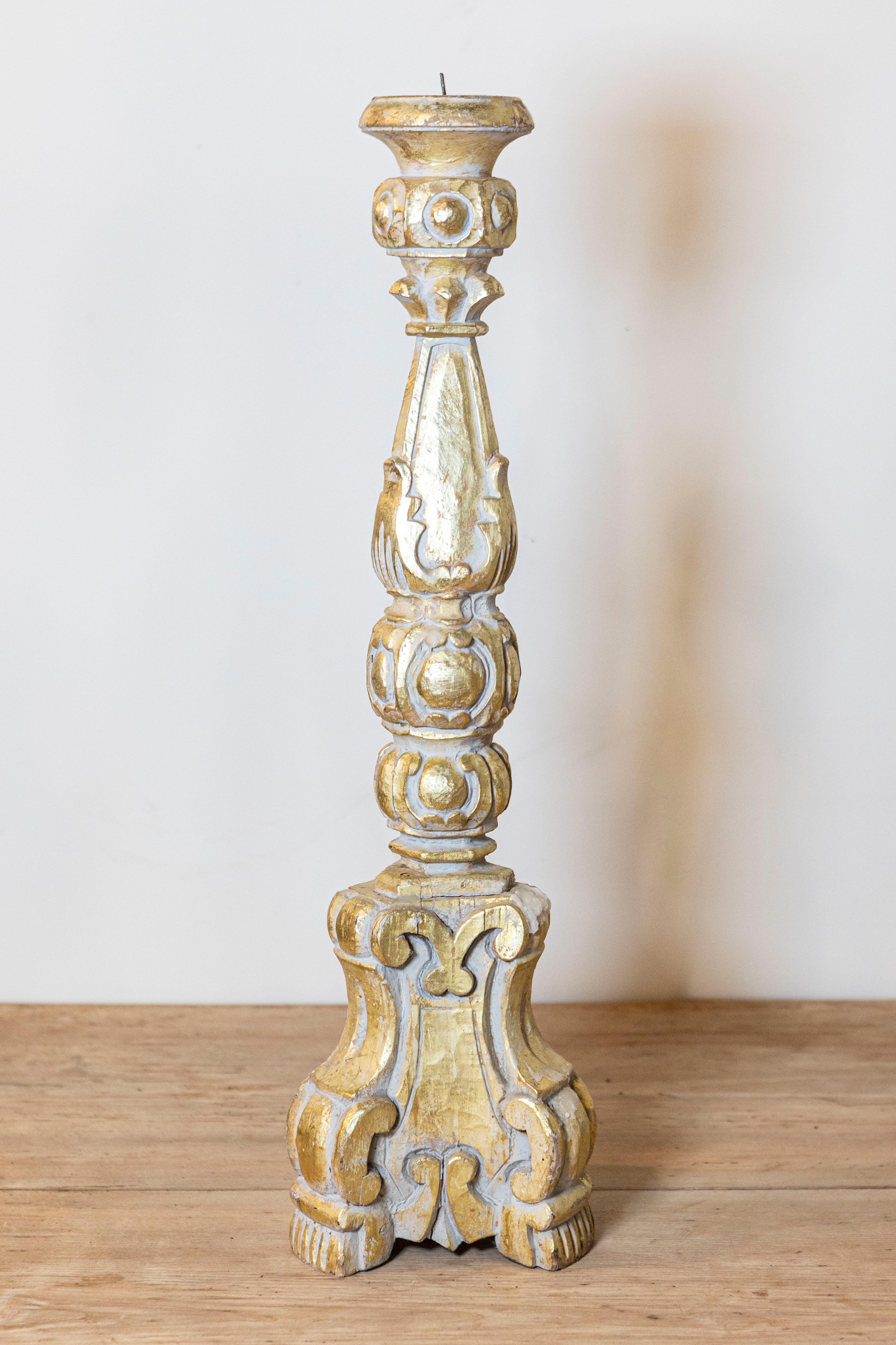An Italian Rococo style giltwood candlestick from circa 1890 with carved scrolling décor. This Italian Rococo-style giltwood candlestick, dating back to circa 1890, exudes opulence and elegance. Its ornate design is a testament to the craftsmanship