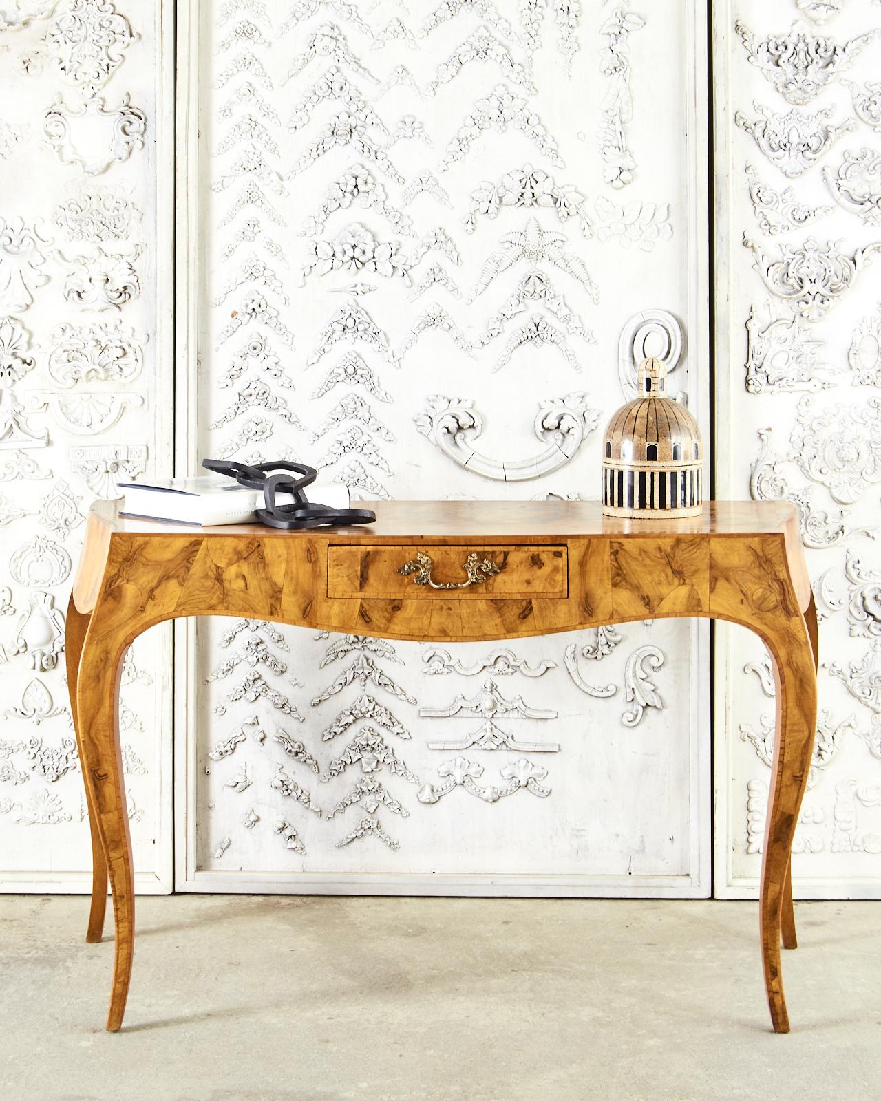 Fantastic Italian ladies writing table or console table featuring a rich burlwood veneer. The frame has elegant curves with graceful serpentine aprons and cabriole style legs. Made in the grand Rococo style. Centered by a single storage drawer the