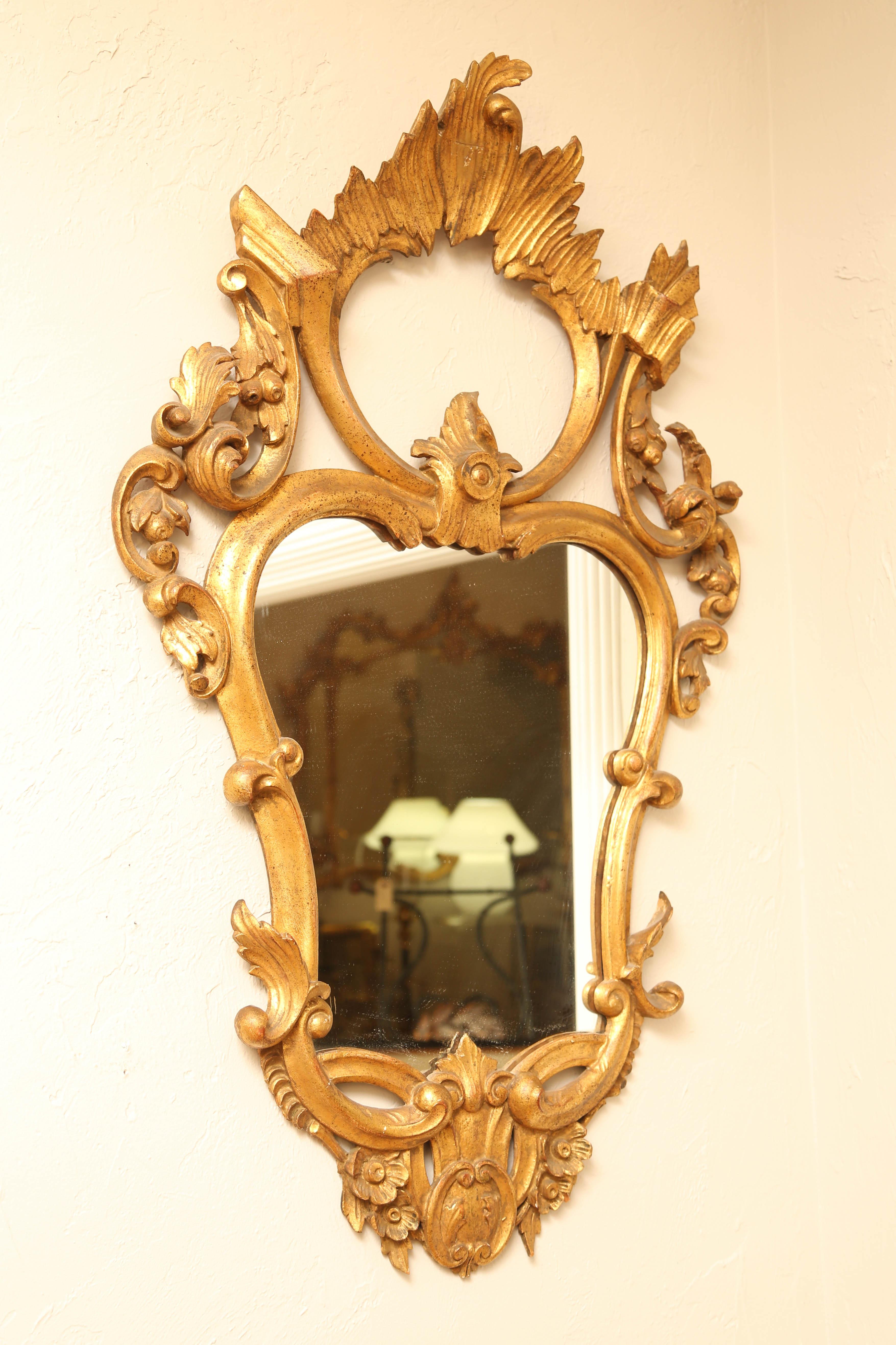 Carved and gilded shield shaped Rococo style Italian mirror.