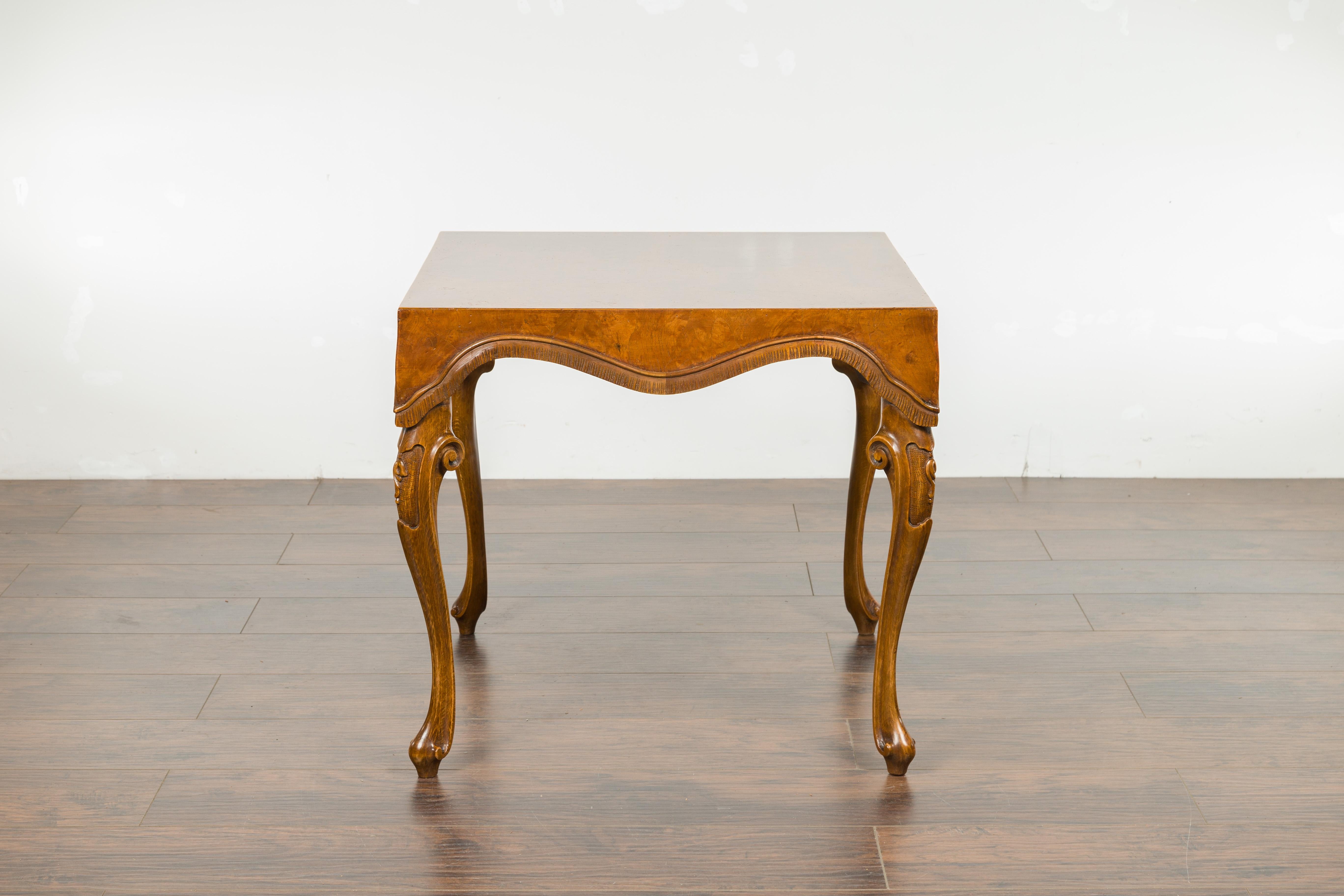 An Italian Rococo style walnut and olive wood square top side table from the mid-20th century, with cabriole legs. Created in Italy during the midcentury period, this walnut and olive wood side table charms us with its square top adorned with a