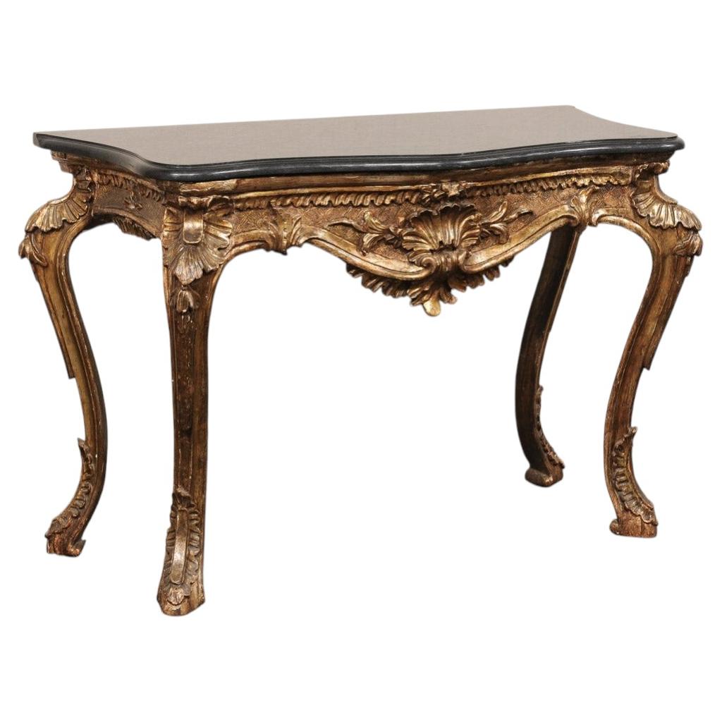 Consola de estilo rococó italiano, con tallas ornamentales y forma serpenteante, con tapa de mármol, siglo XIX.