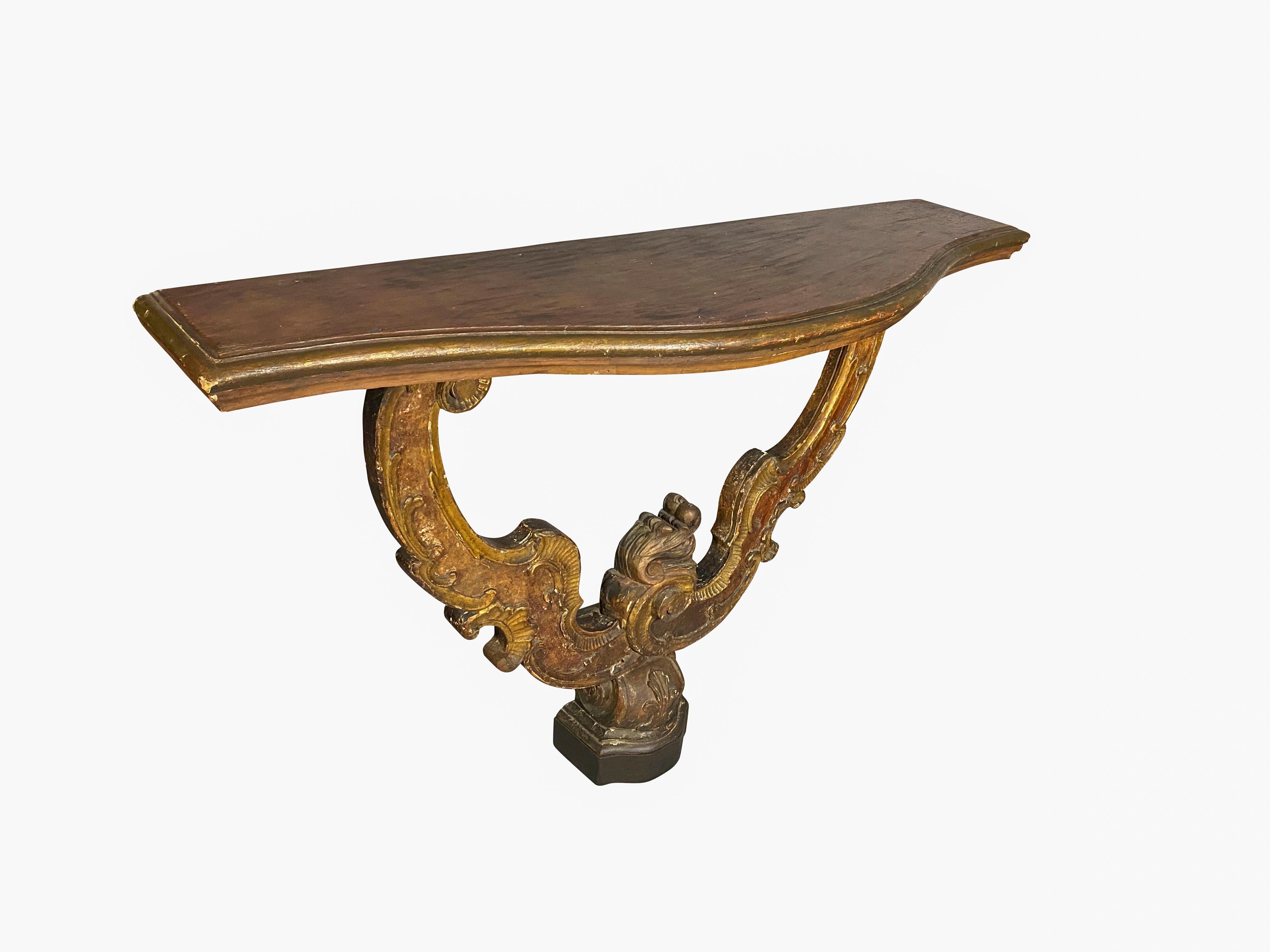 With a serpentine faux marble top over a carved and painted support joined by a shaped footed base. Provenance; William Hodgins Interior design.