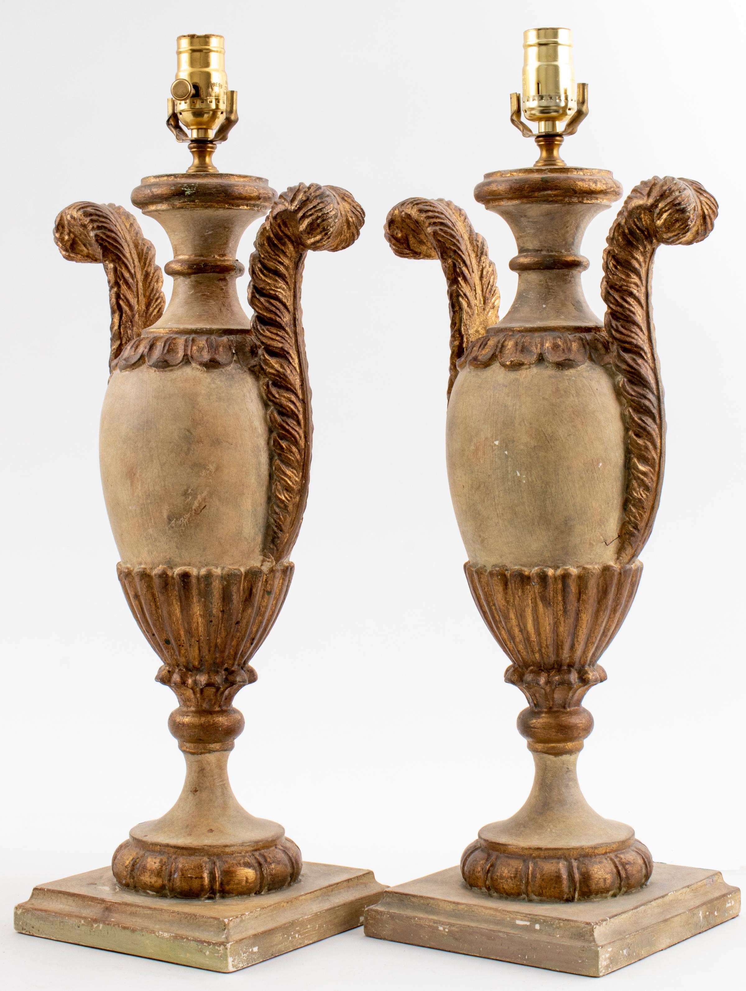 Pair of Italian Rococo style cream painted table lamps, in the 18th century taste, decorated with acanthus and lobed motifs, on stepped plinth bases. Measures: 23” height to fixture x 9.75” diameter.