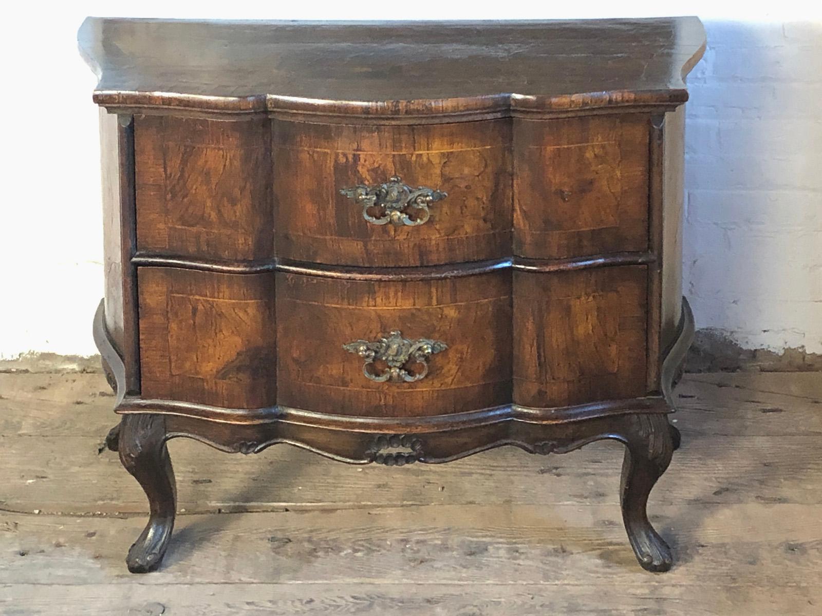 Small Italian (Venice area) Rococo style Serpentine shaped commode, Walnut with thick Radica Veneer and inlay with deep, rich color. Two drawers with ornate, heavy cast brass pulls. 
A very charming, elegant accent piece of petite size and grand