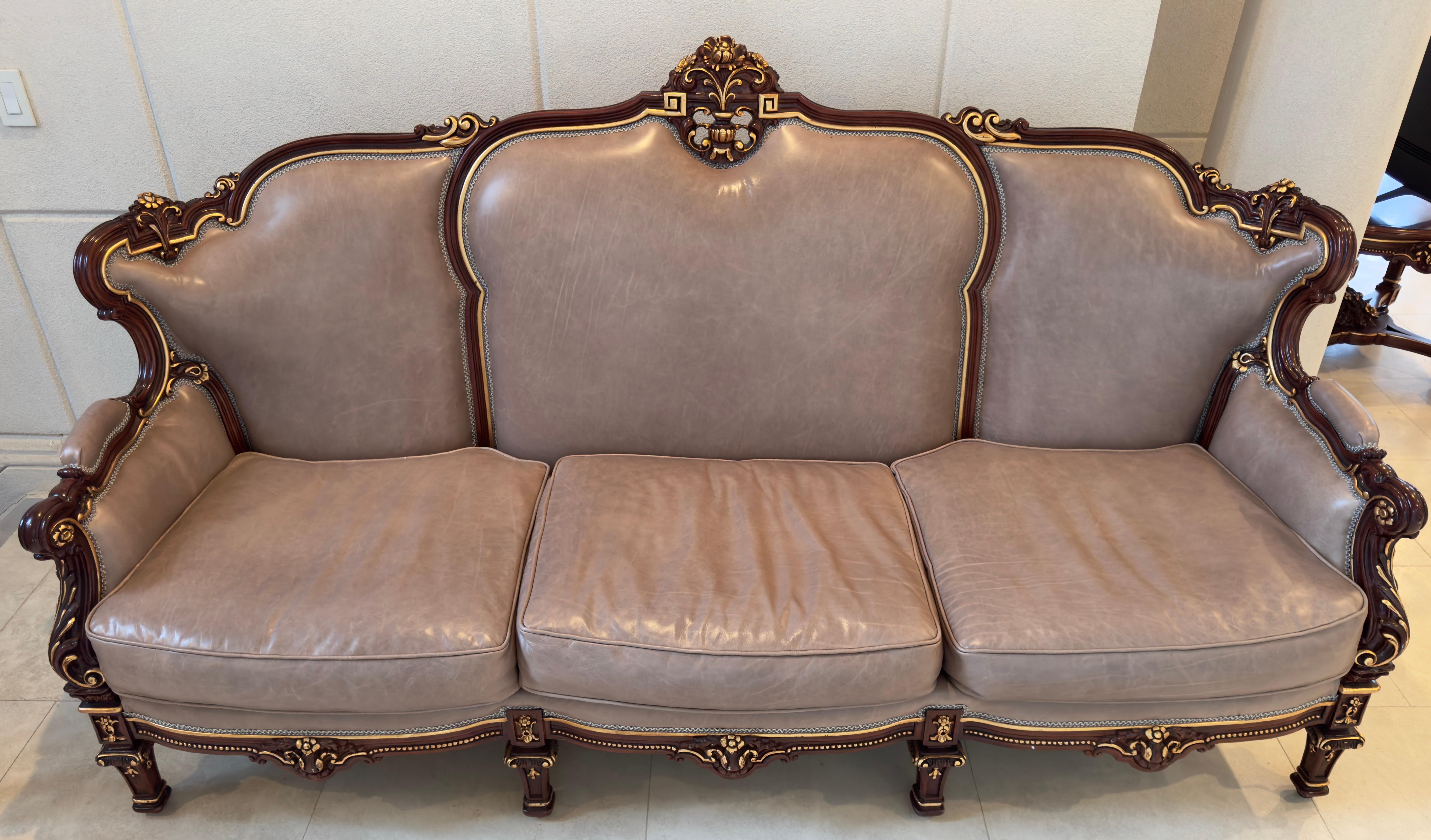 An exquisite Italian Rococo Style leather and mahogany sofa. Imbued with the essence of opulence, this sofa is a symphony of fine craftsmanship and timeless design.
Fashioned from the finest mahogany, the frame of this sofa is a work of art in