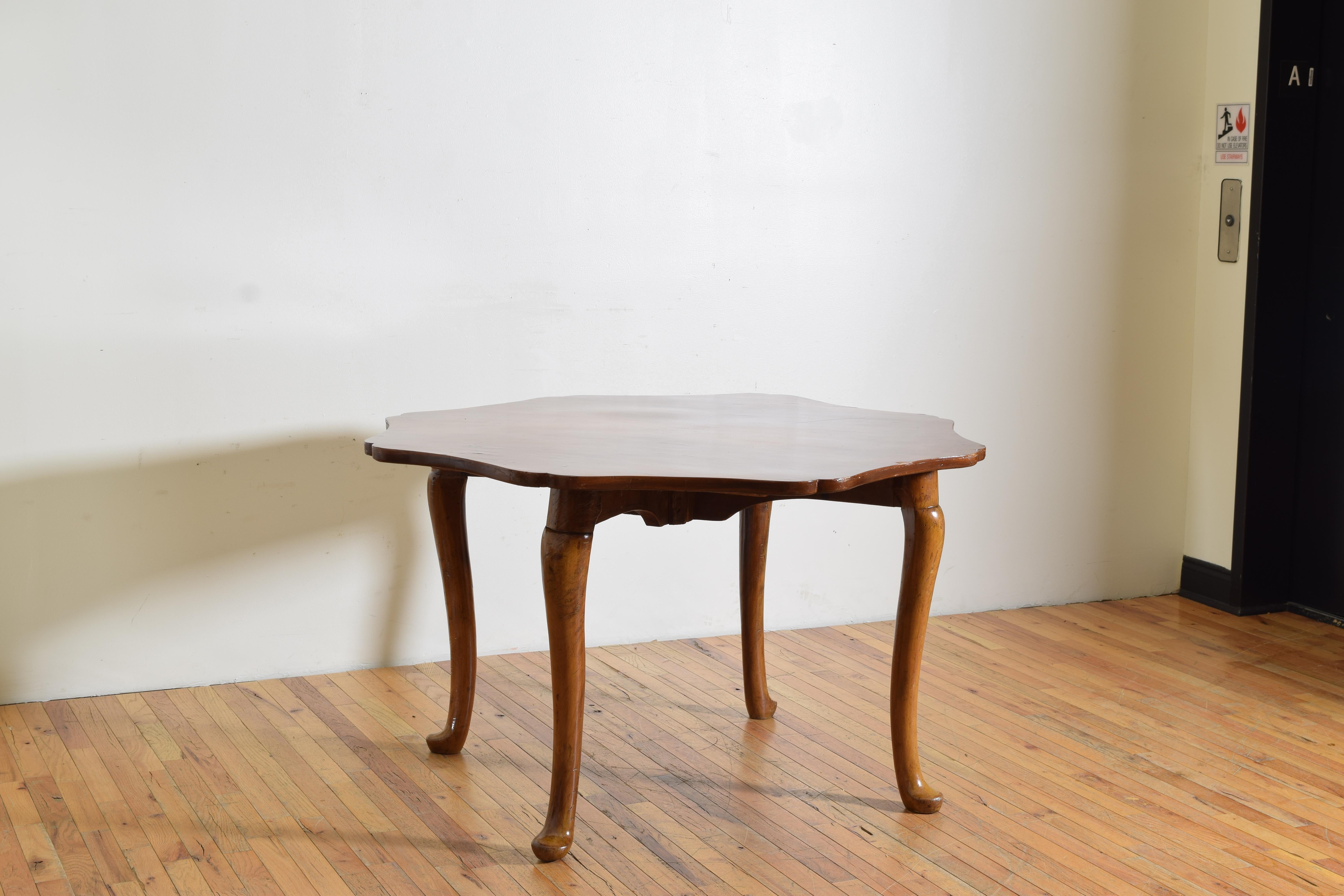 The top of octagonal shaped with curved corners and concave edges and covered in 4 equals; sections of walnut veneers, raised on a two piece solid walnut base featuring cabriole legs and pad shaped feet