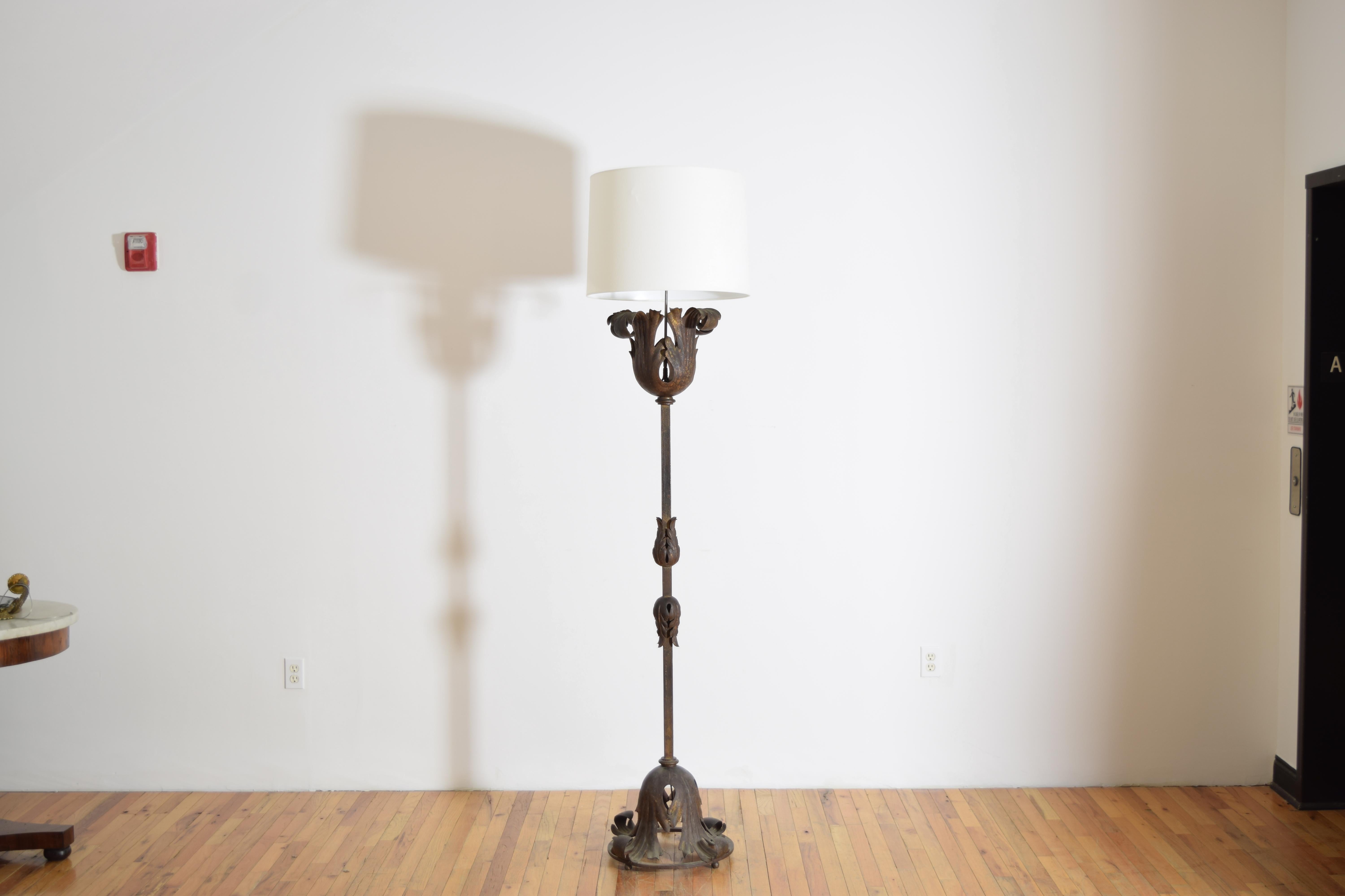 having a flower shaped top of gilt metal atop a square iron shaft, the base and upside down gilt metal flower sitting within an iron ring, height measured to top of shade