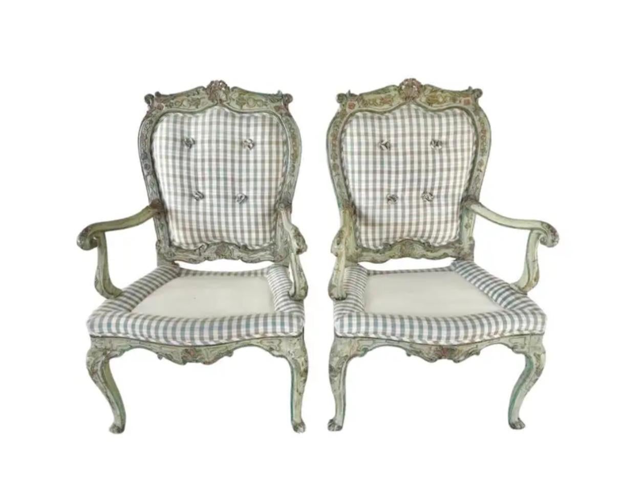 A Pair of 18th Century Italian Rococo Armchairs. Each chair is carved and polychrome painted in soft greens, pinks, and blues, with delicate floral accents. The frames display the graceful curves and ornate hand carved scrollwork characteristic of