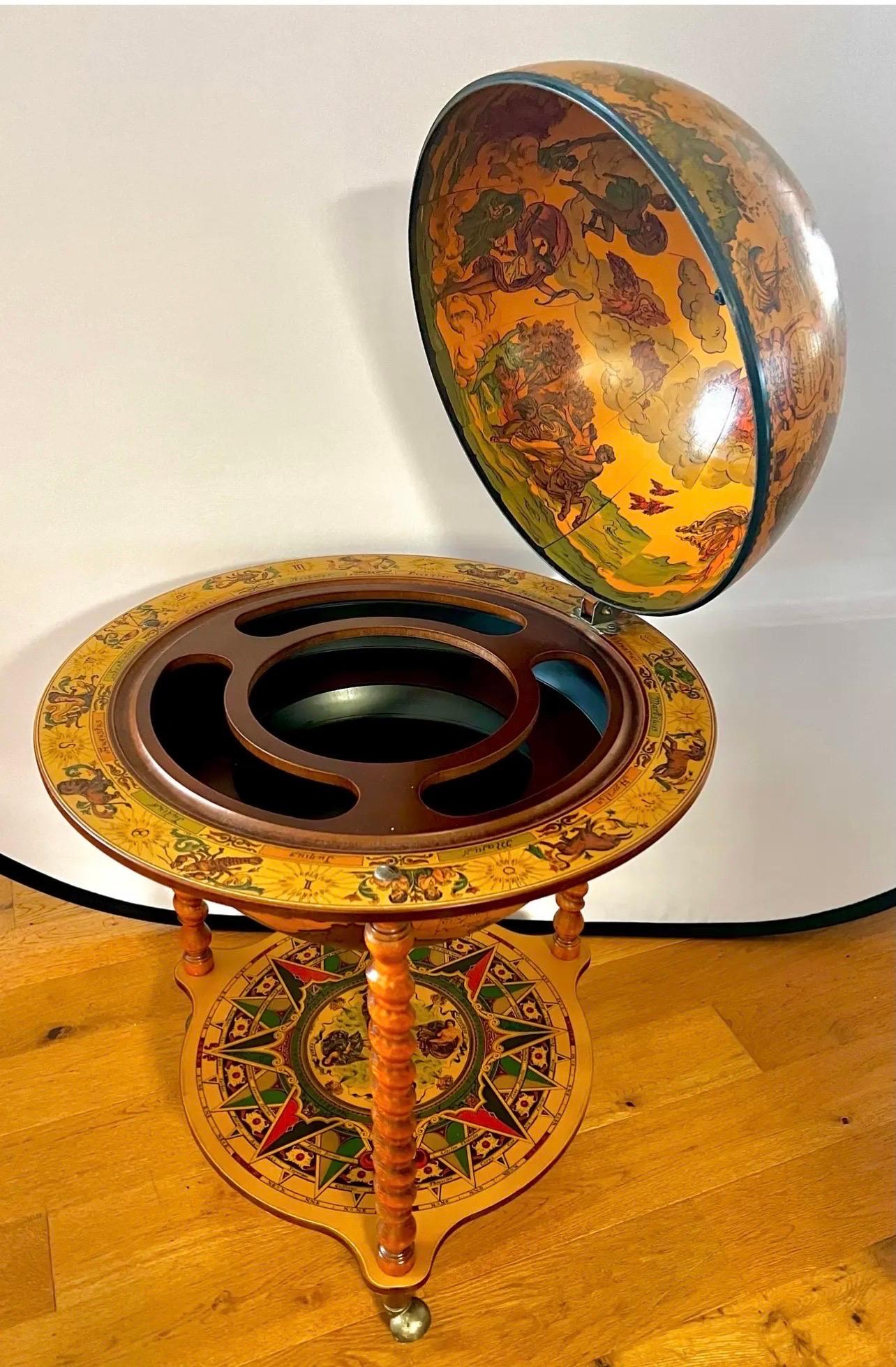 Unique rolling bar cart in the shape of a world globe supported on barley twist legs with castors for ease of movement.  Globe opens to storage for bottles, glasses and bar accessories and features zodiac signs all around.