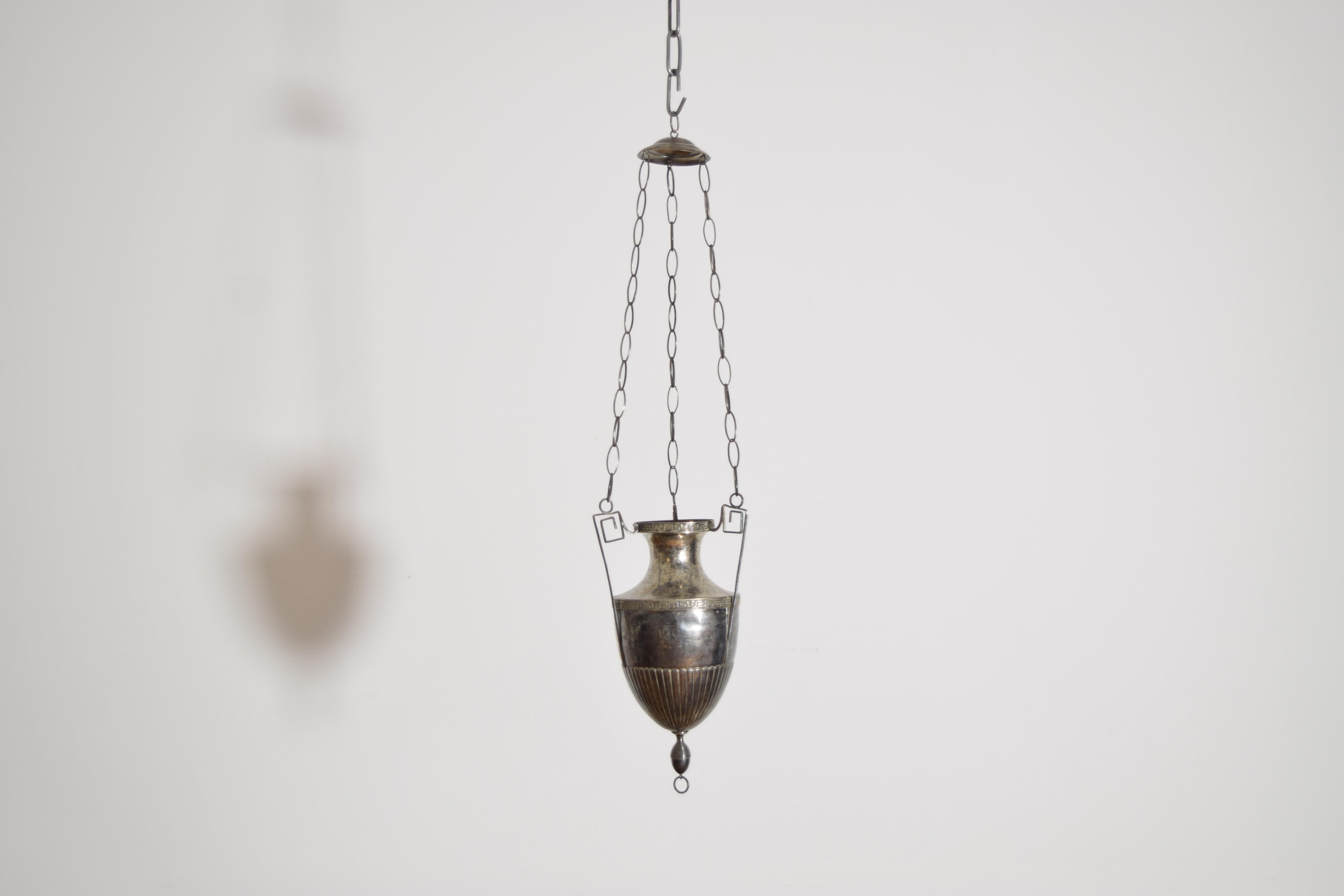 suspendue à son baldaquin et à ses chaînes d'origine, avec des poignées en forme de clé grecque et une décoration incisée en forme de clé grecque sur le bord supérieur, le corps de forme néoclassique et coulé de manière experte, qui doit maintenant