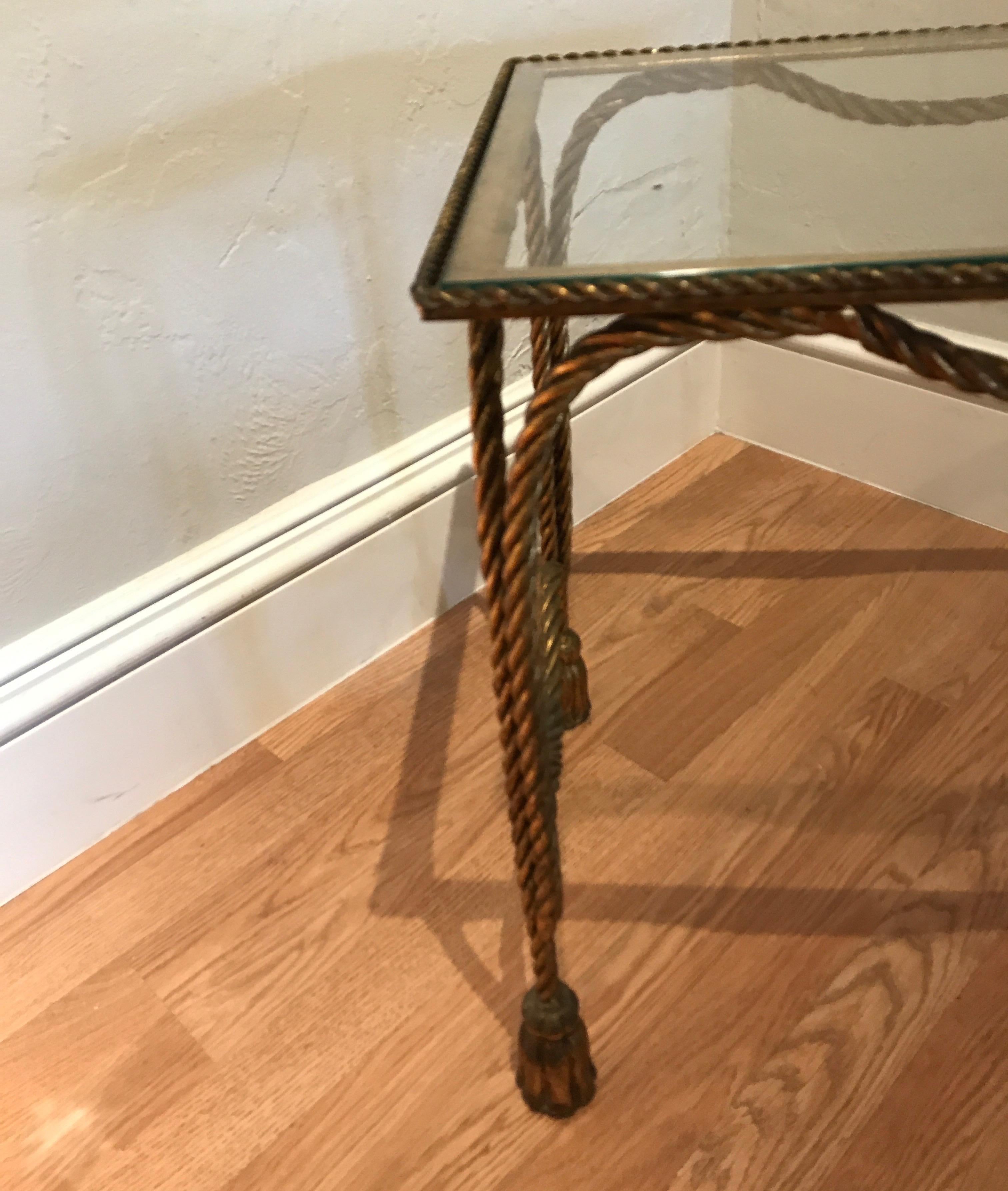Hollywood Regency gilded iron rope and tassel end table with glass top.