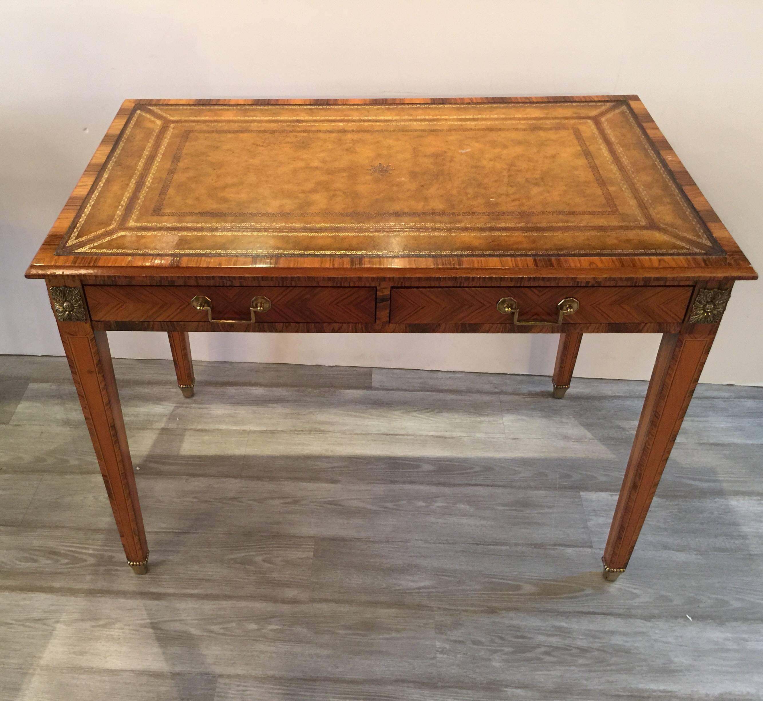 Handsome rosewood and leather desk with ormolu mounts. The warm leather top with figurative rosewood frame and legs. The apron with two drawers. The tapering legs with rosewood along the sides. The top has to pull out trays that extend the sides 11
