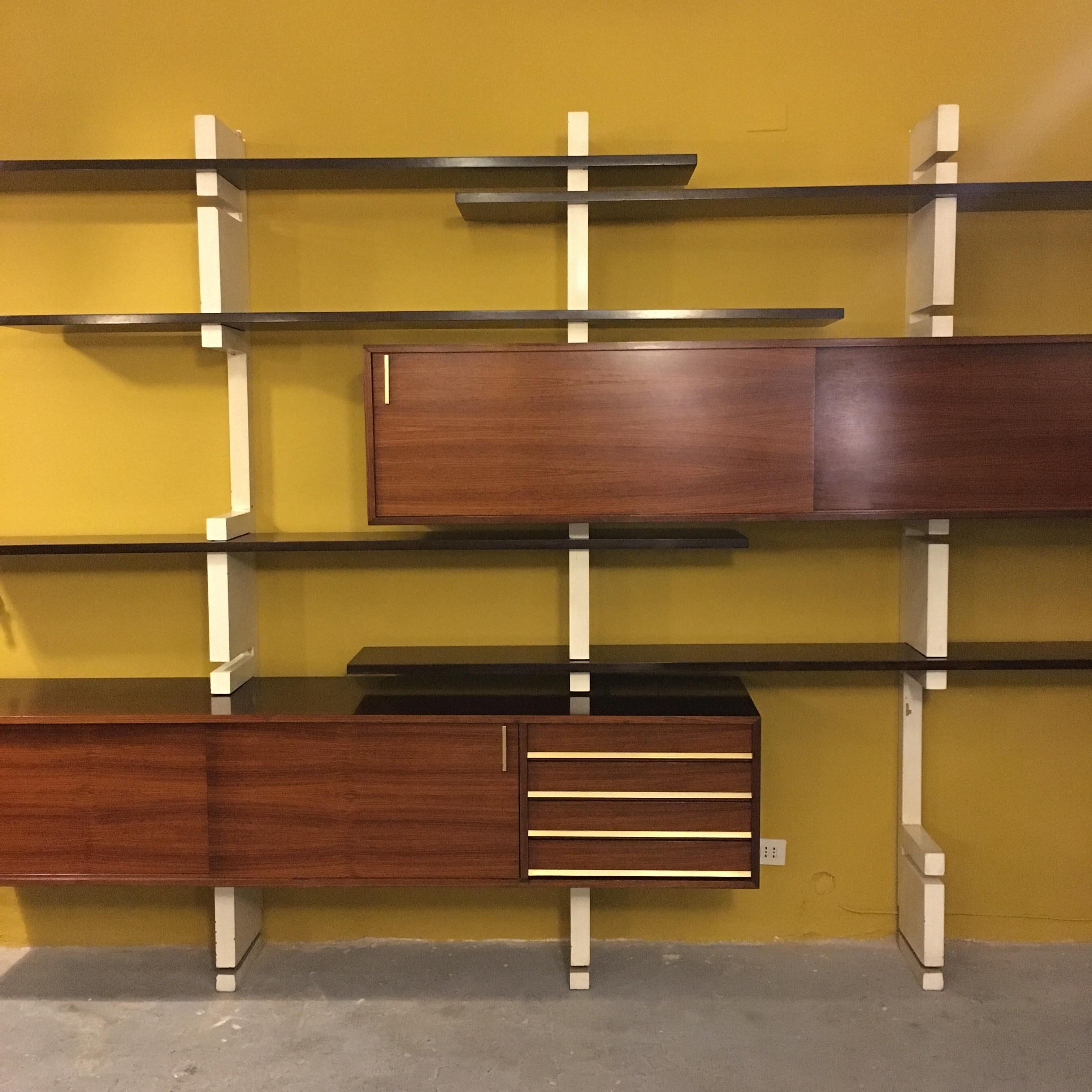 Italian rosewood and white wooden Extenso bookcase by AMMA Torino, 1960s
Extensible rosewood wall Extenso bookcase with white enamelled wooden uprights and brass details
Composed of two container modules, one with sliding doors and the other with