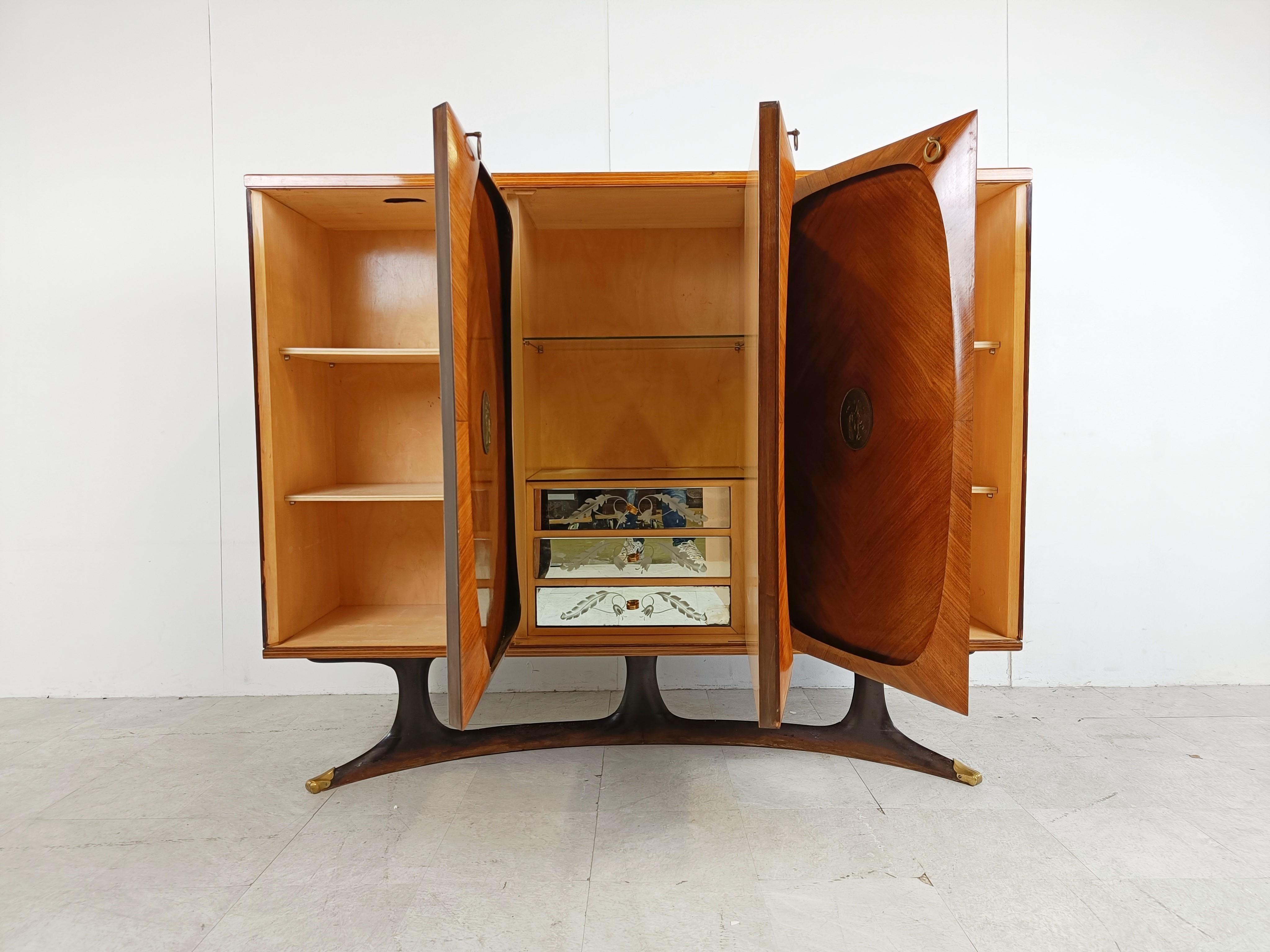 Très élégant meuble haut du milieu du siècle dernier, conçu par Vittorio Dassi pour Lissone.

Ce meuble haut en bois de rose est composé de trois portes, chacune décorée d'un médaillon en laiton. 

Les portes sont magnifiquement conçues avec un bord