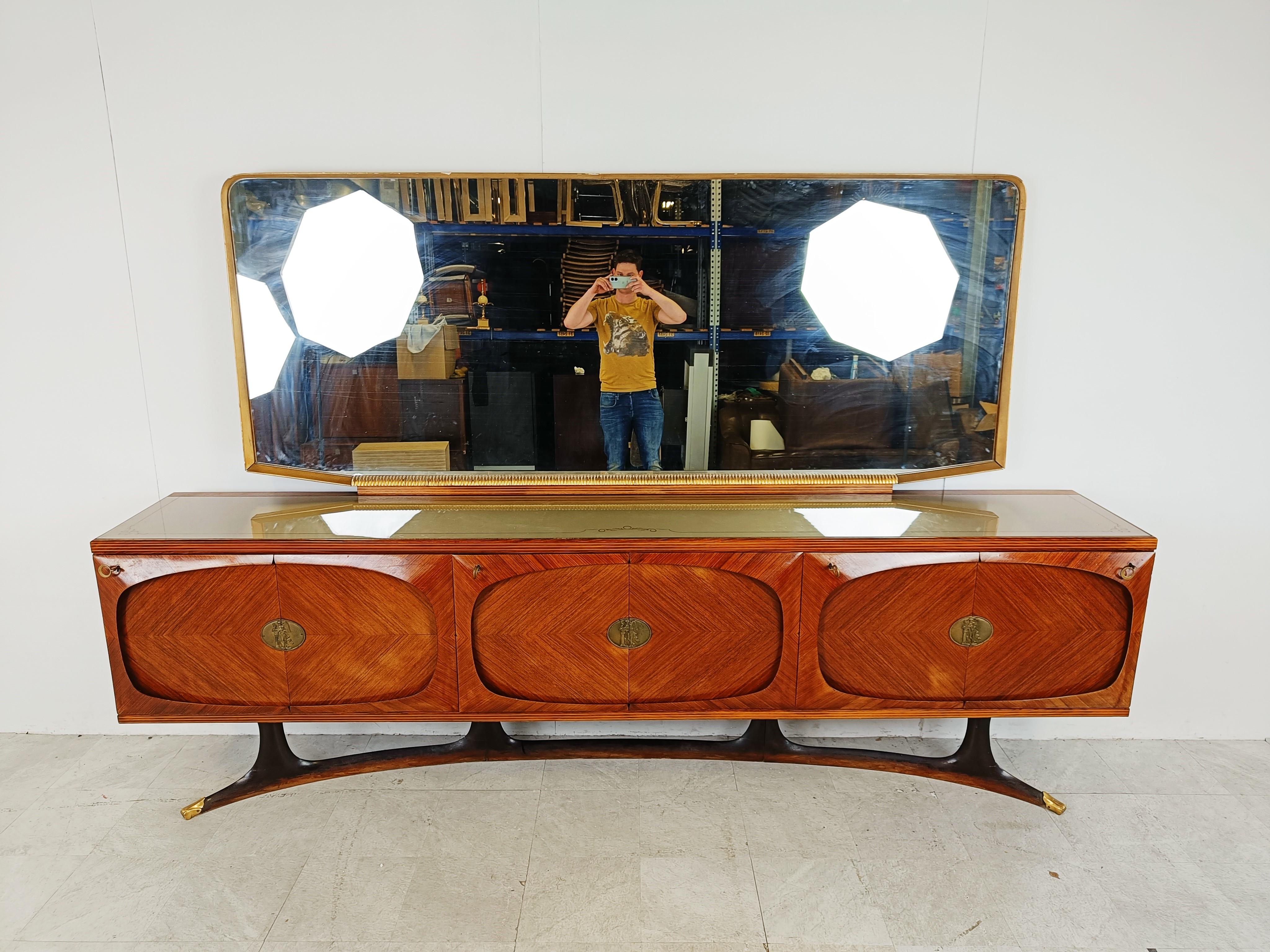 Sehr elegantes Sideboard mit Spiegel aus der Mitte des Jahrhunderts, entworfen von Vittorio Dassi für Lissone.

Diese Anrichte aus Palisanderholz besteht aus sechs Türen, die jeweils mit einem Medaillon aus Messing verziert sind. 

Die Türen sind