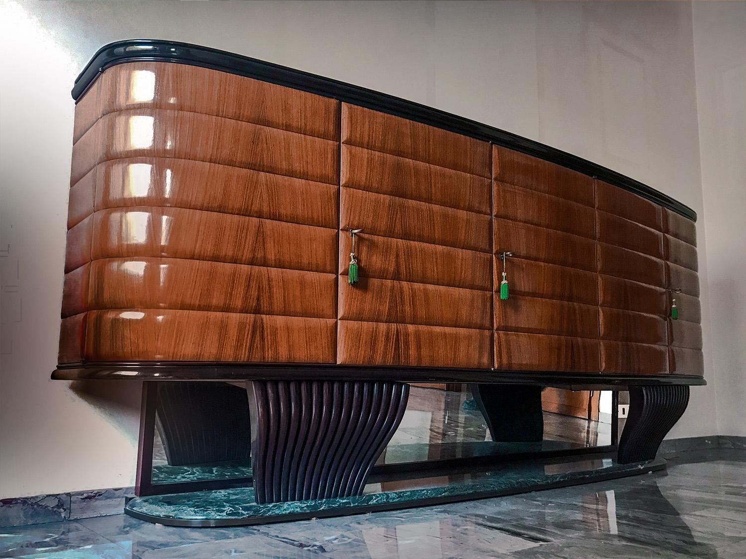 Important and very rare rosewood sideboard with glass top in black opaline, designed by Vittorio Dassi in the 1950s.
The body is supported by two grooved solid curved mahogany wood elements shaped like shell, fixed on embossed base made in precious