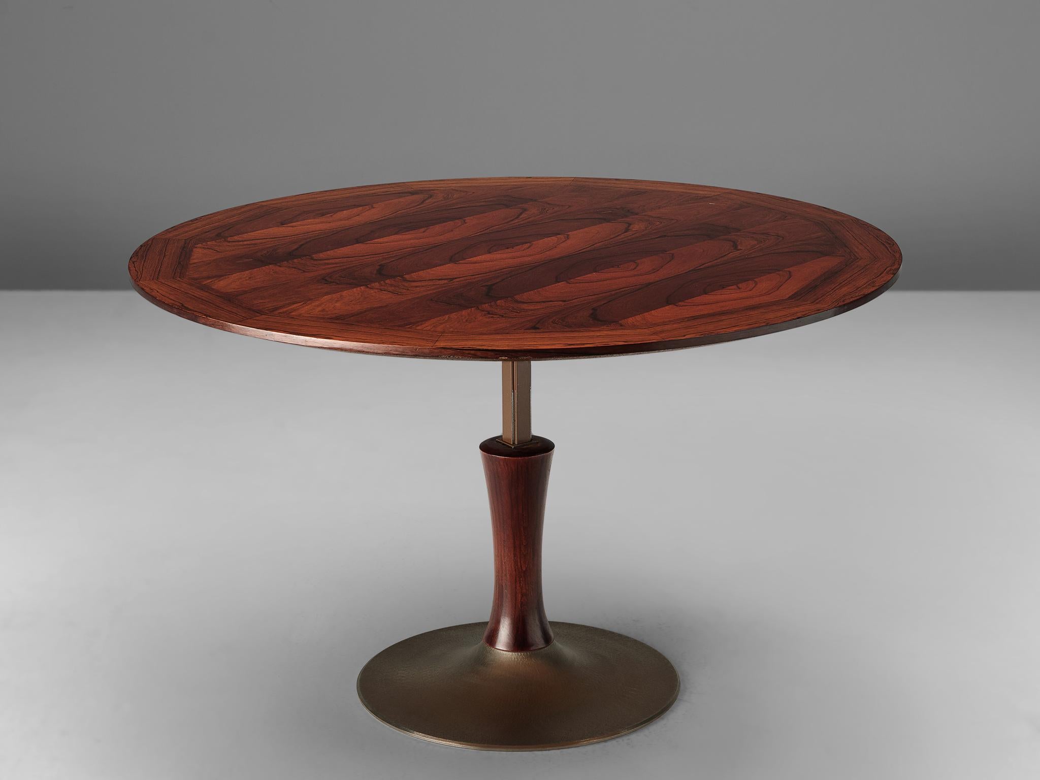Adjustable table, rosewood and metal, Italy, 1960s

An adjustable round dining table that can be converted to a height of 20.7in/52cm, which makes it suitable as a coffee table as well. The circular table top is made with bookmatched rosewood
