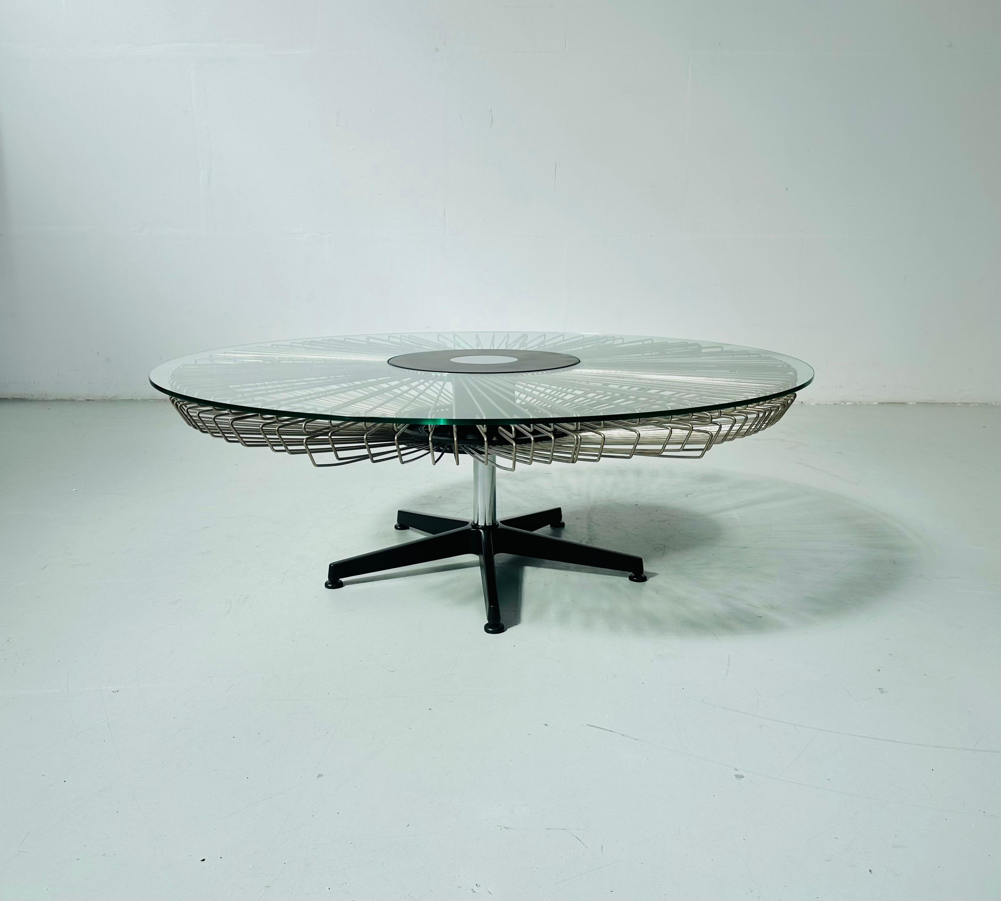 This is one of the 8 coffee tables designed and manufactured for several fashion shows for Prada in the nineties. The thick glass top has a large opening in the middle were the black base comes through. The glass table top rests  on exactly 100