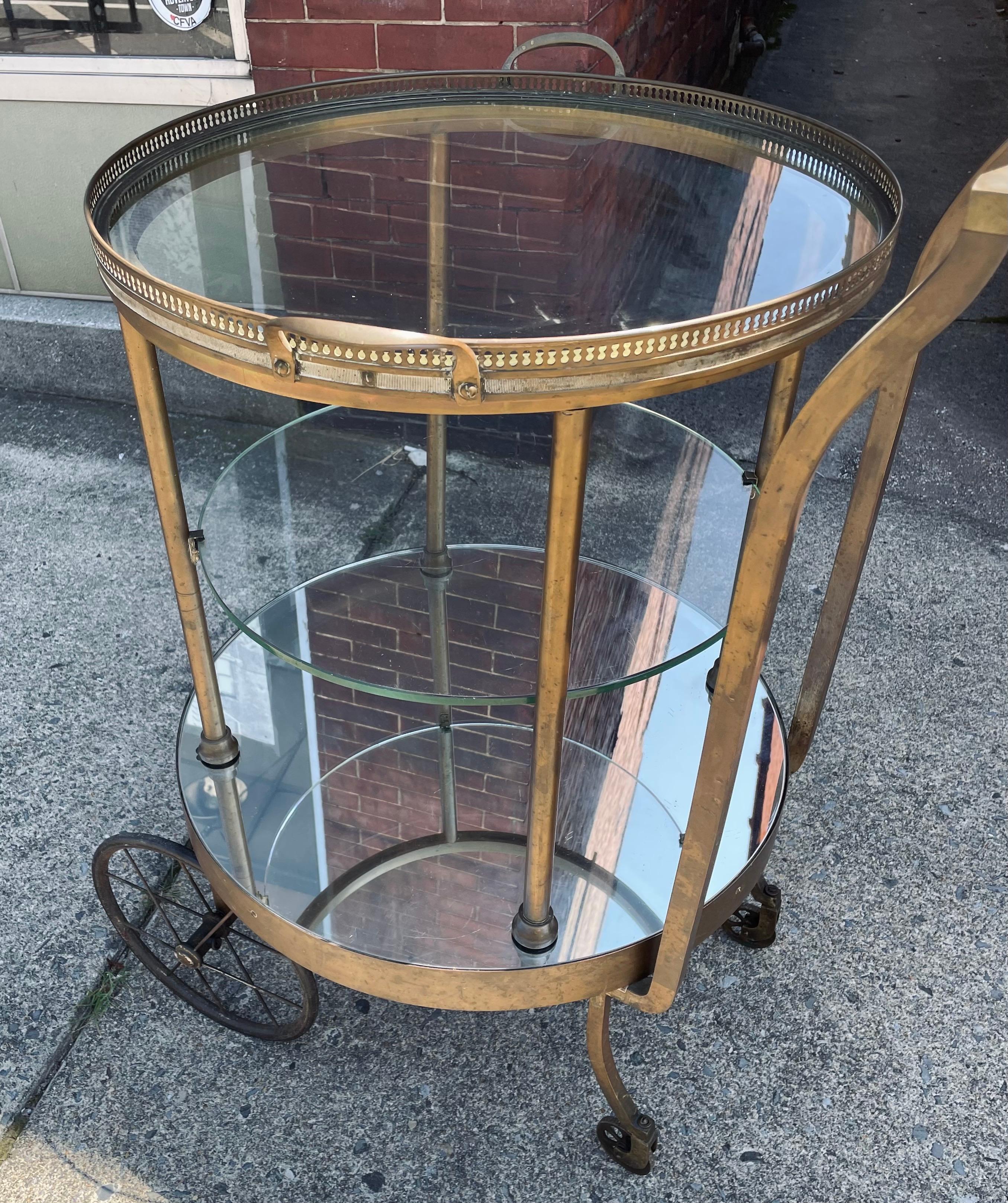 Dieser Barwagen aus Messing mit Glasböden und verspiegeltem Boden hat einen wunderbar schlichten Art-Déco-Stil und ist von fantastischer Verarbeitungsqualität. Das Besondere daran ist, dass sich die gesamte runde Mitte leicht drehen lässt, die
