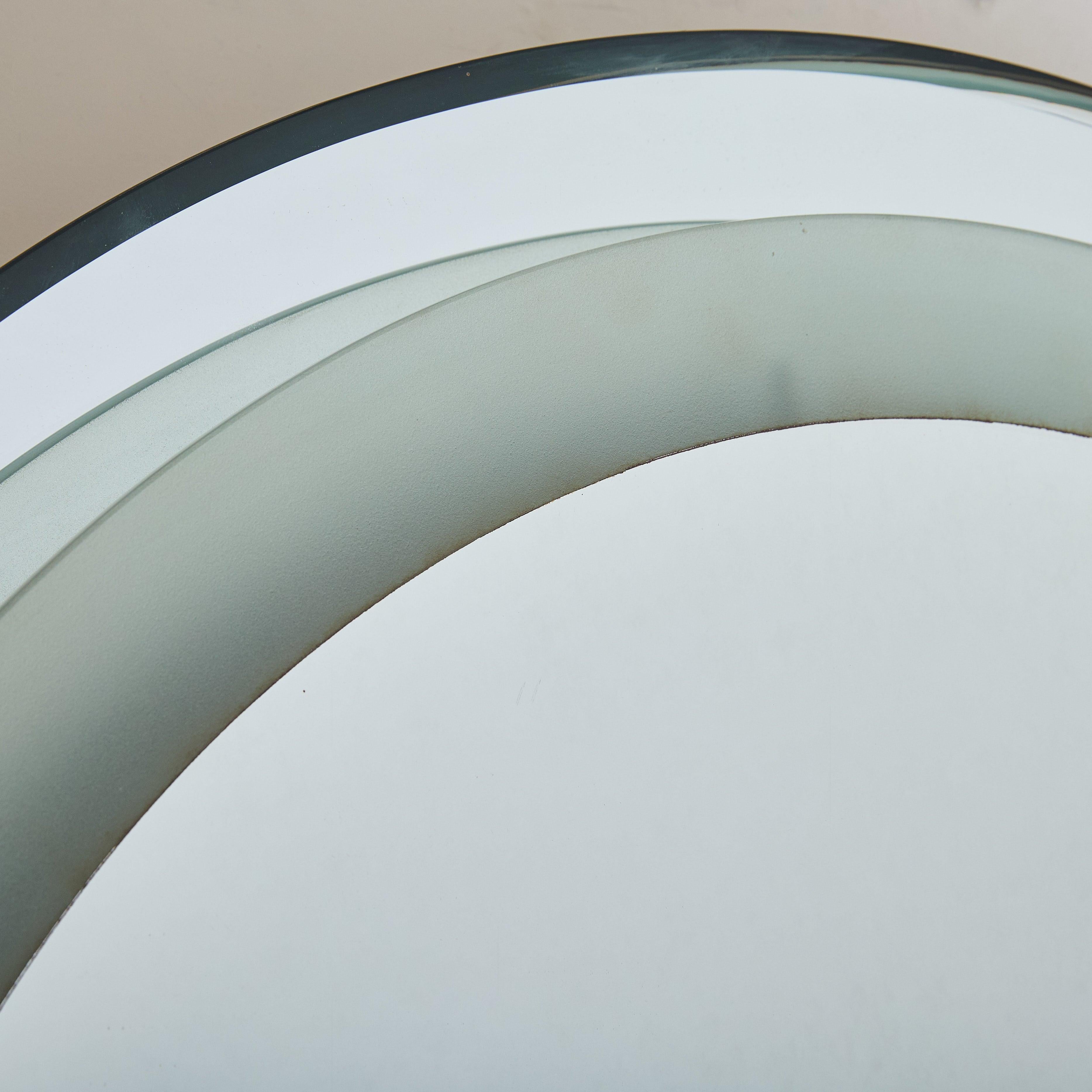 Vendus et tarifés individuellement. Un vendu/un disponible

Miroir mural italien des années 1970 défini par sa composition en couches : un miroir rond central encadré par une bande extérieure de verre satiné dans un ton aqua doux. Subtilement