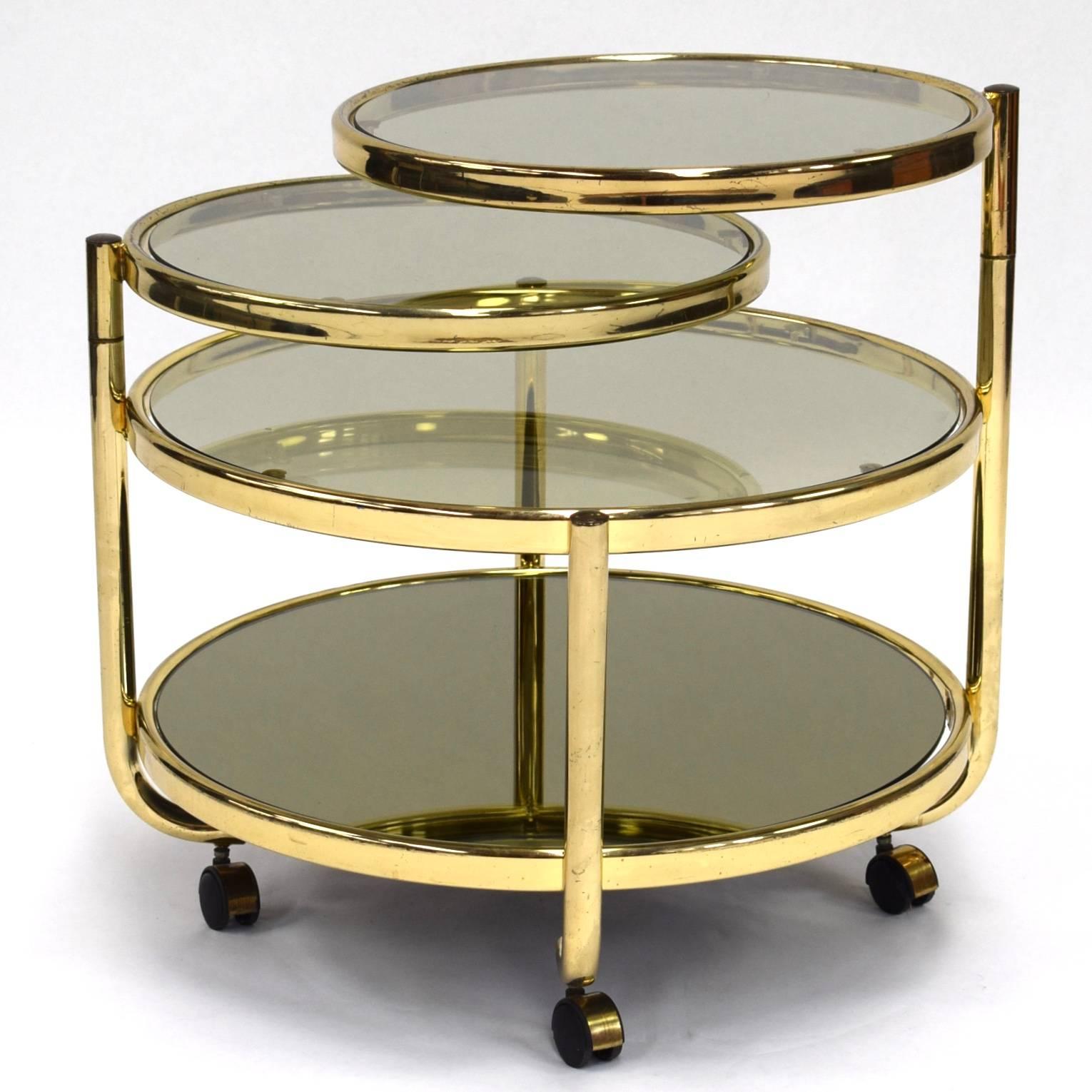 Elegant Italian brass and smoked (mirror) glass cocktail cart. The two upper tops can be turned 360 degrees.

Designer: Unknown
Manufacturer: Unknown
Country: Italy
Model: Bar cart / Serving table / Coffee table
Design period: 1970s.
Date of